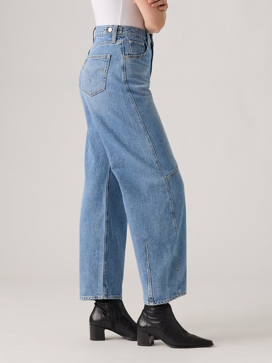 Light blue denim high-waisted wide-leg jeans paired with black heeled ankle boots on a neutral background.