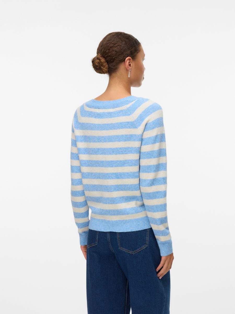 Light blue and white striped sweater paired with dark blue denim jeans on a standing figure viewed from the back.