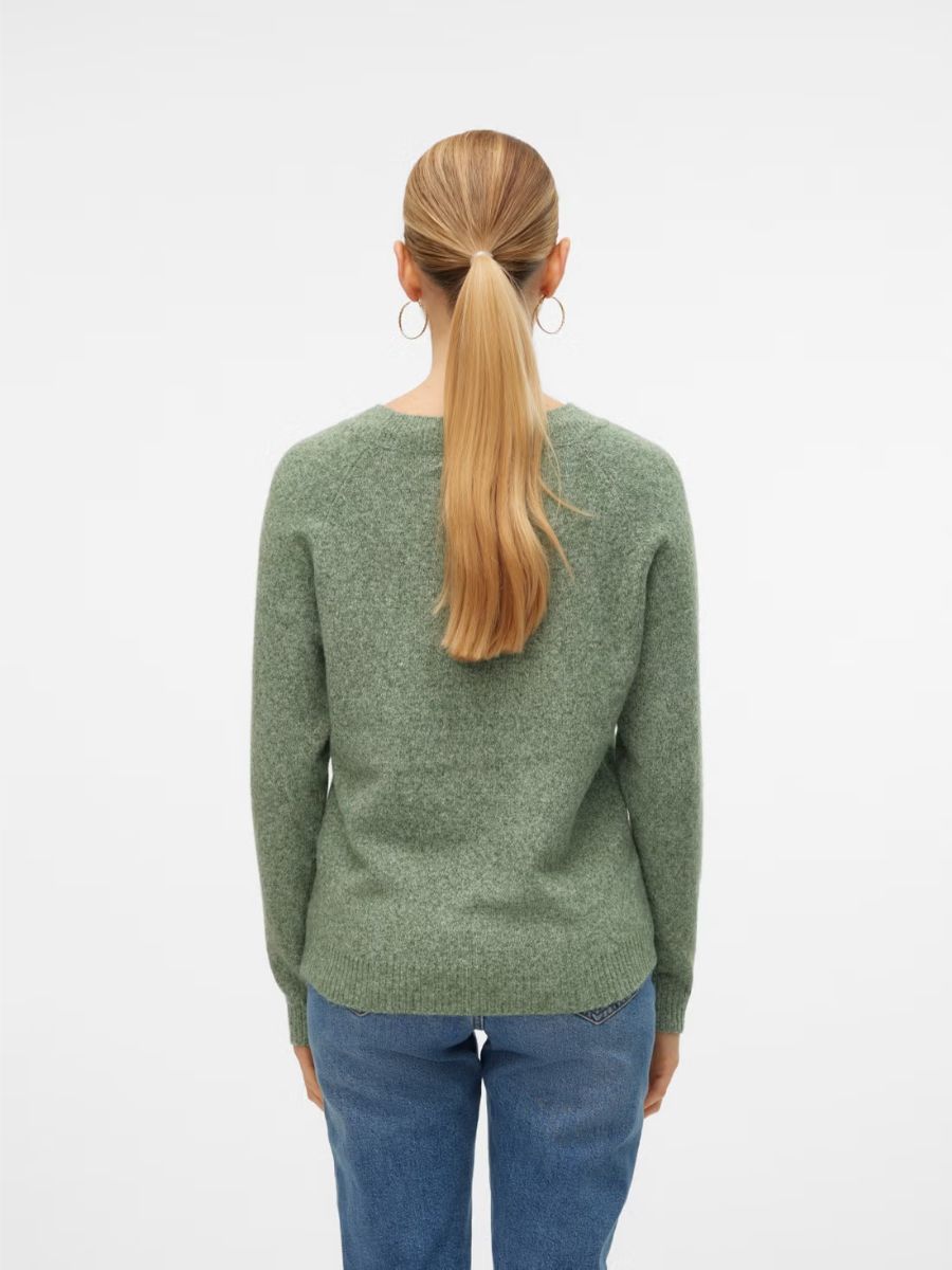Back view of a green knit sweater paired with blue denim jeans on a model with a ponytail hairstyle.