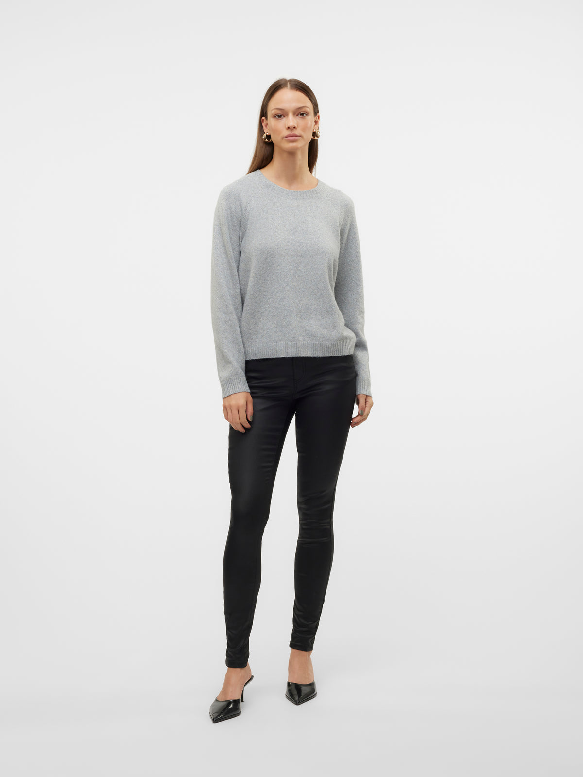 Full-length model in a light gray sweater, black pants, and black pointed shoes against a white background