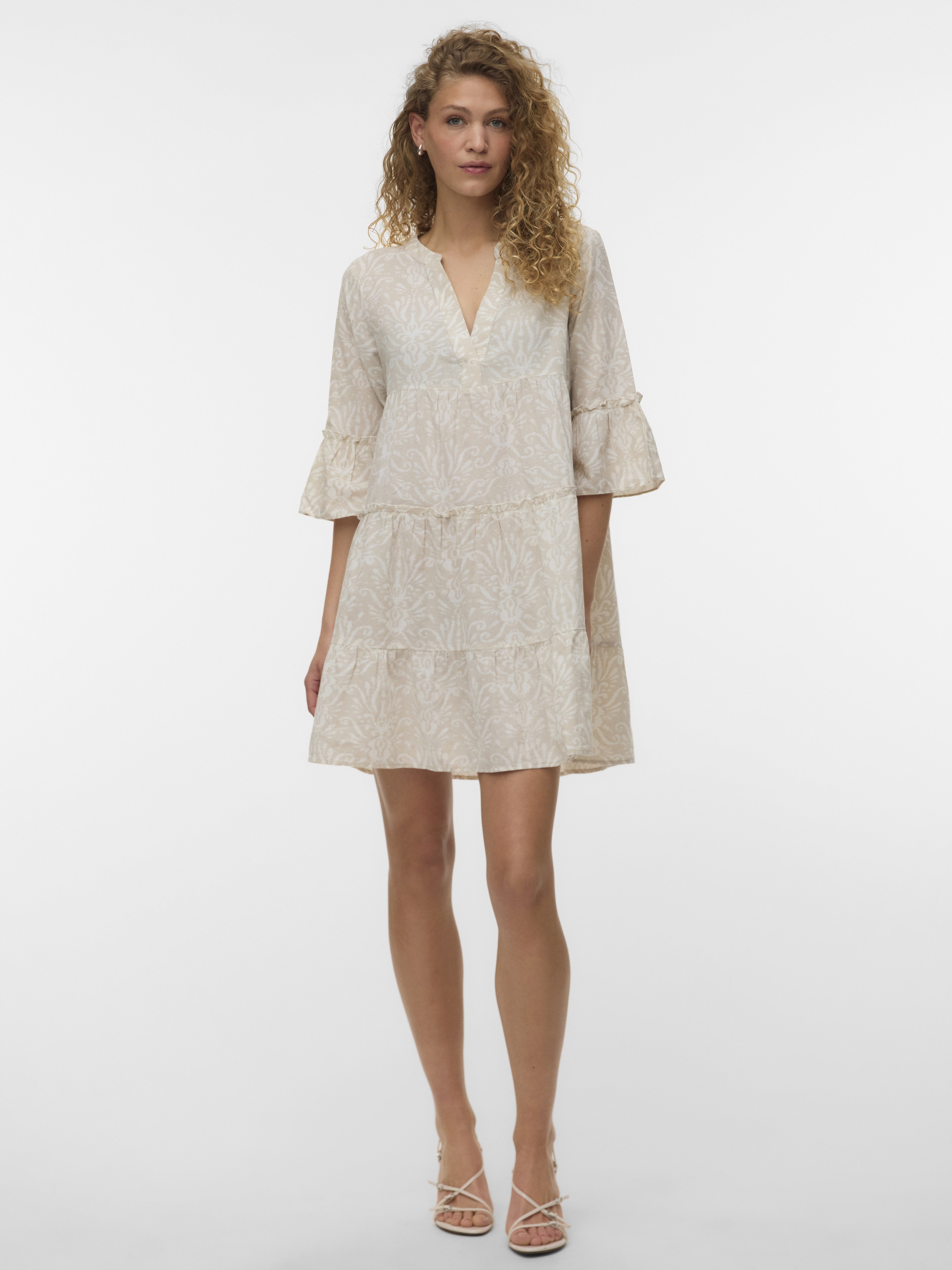 Vero Moda Dici Tiered Midi Dress in beige with subtle pattern, featuring tiered layers and flared sleeves.