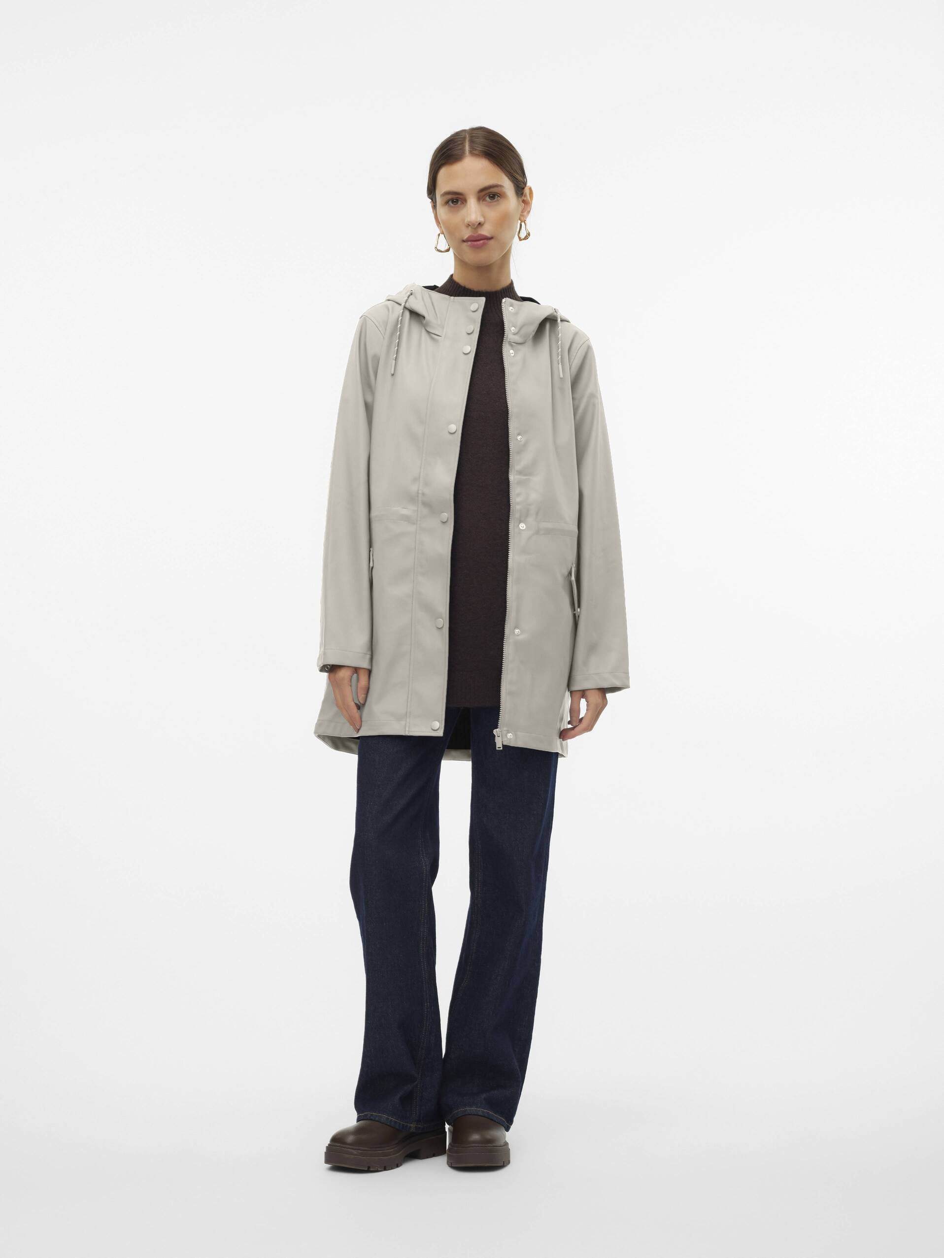 Light beige Vero Moda Malou Hooded Rain Jacket styled with dark pants and boots in a minimalist setting