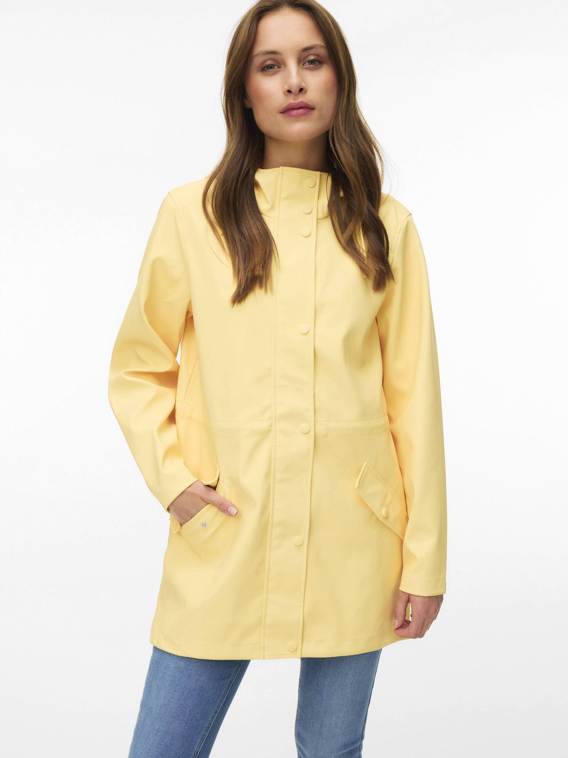 Light yellow Vero Moda Malou Hooded Rain Jacket with front pockets, styled with casual blue jeans outerwear