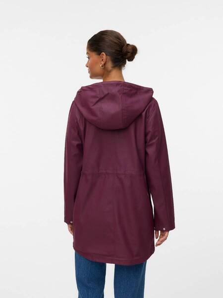 Back view of a person wearing a long maroon hooded coat with long sleeves and blue jeans against a white background.
