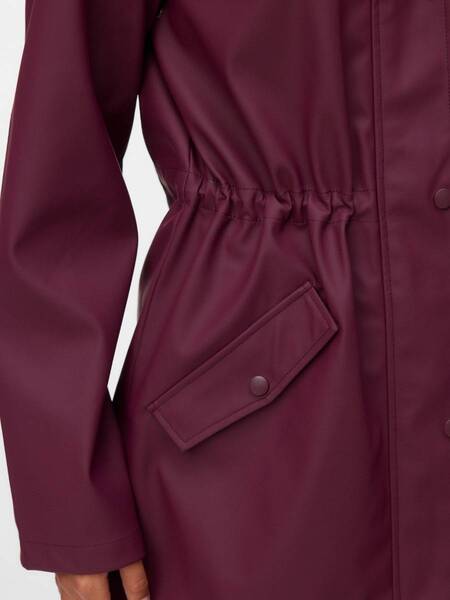 Close-up of a burgundy coat with a cinched waist and a flap pocket secured by a snap button on the side.