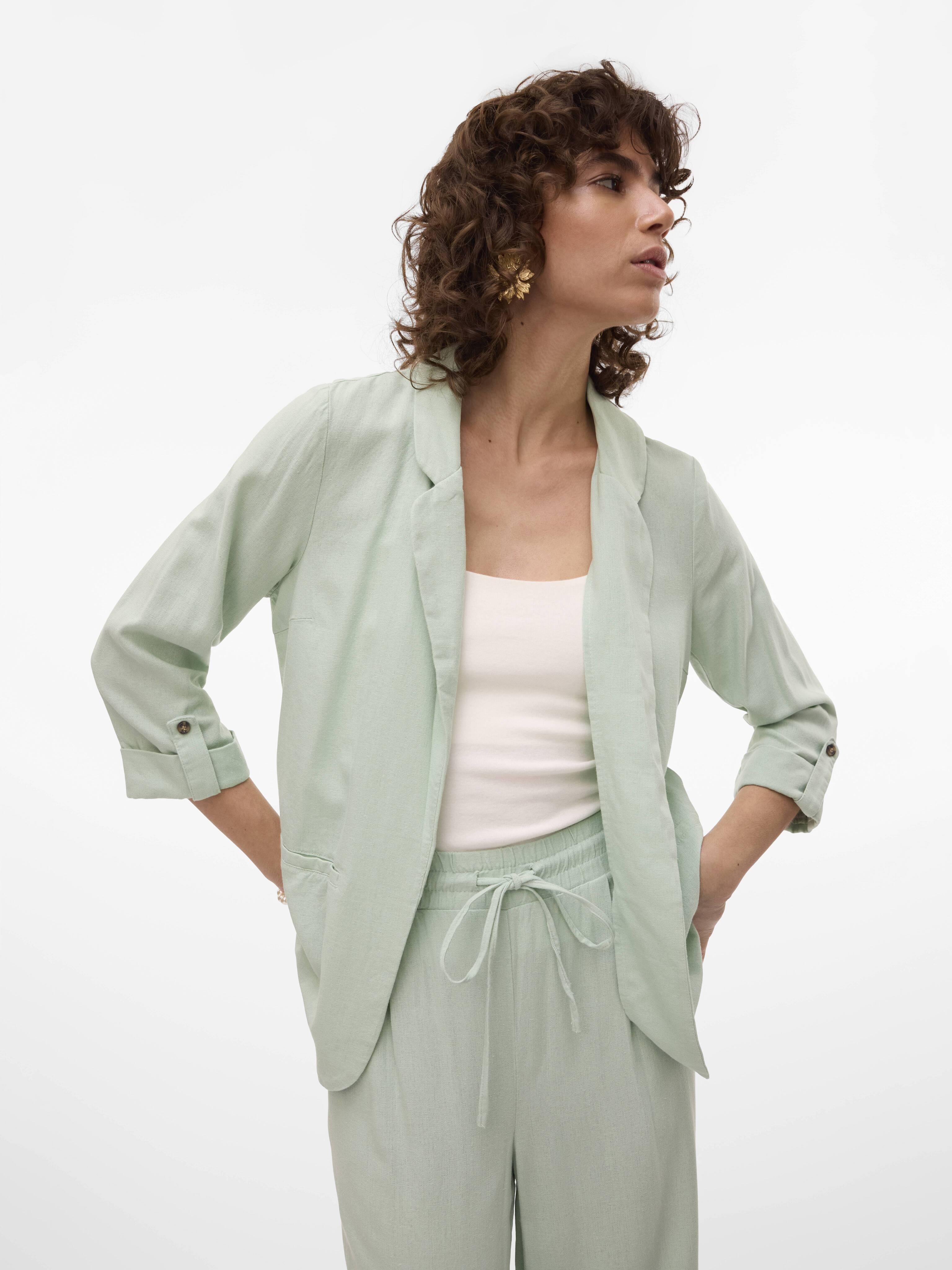 Vero Moda Jensen Blazer in sage green, lightweight fabric, styled with rolled-up sleeves and pockets.