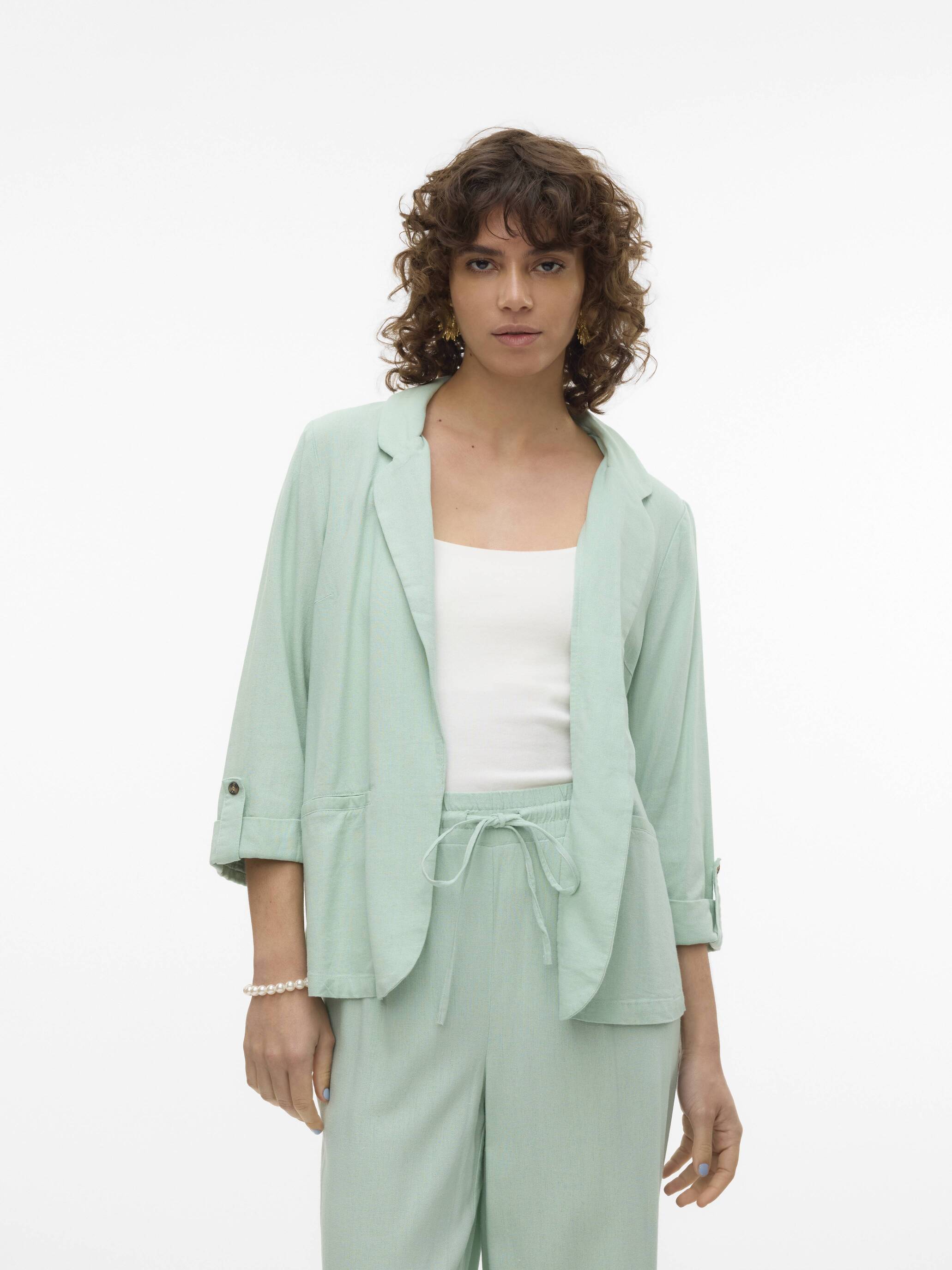 Vero Moda Jensen Blazer in soft sage green displayed with matching trousers and a white top, styled for outerwear.