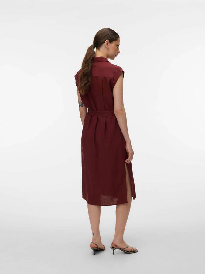 Back view of Vero Moda My Nen Shirt Dress in rust color with sleeveless design and side slit on model.