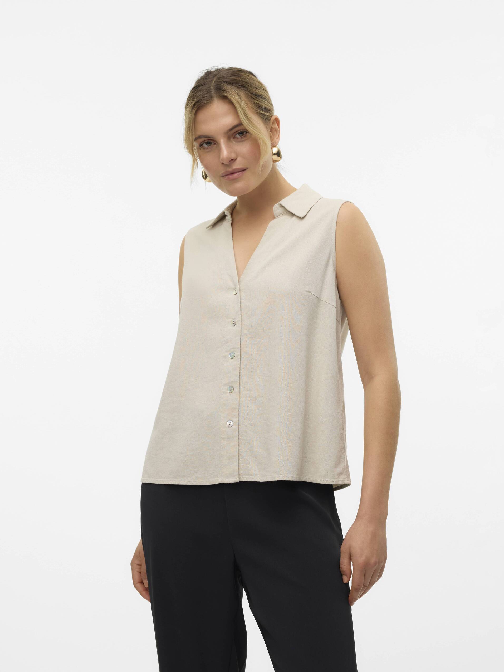 Vero Moda My Nen Sleeveless V-Neck Top in beige with button front and collar, paired with black pants.