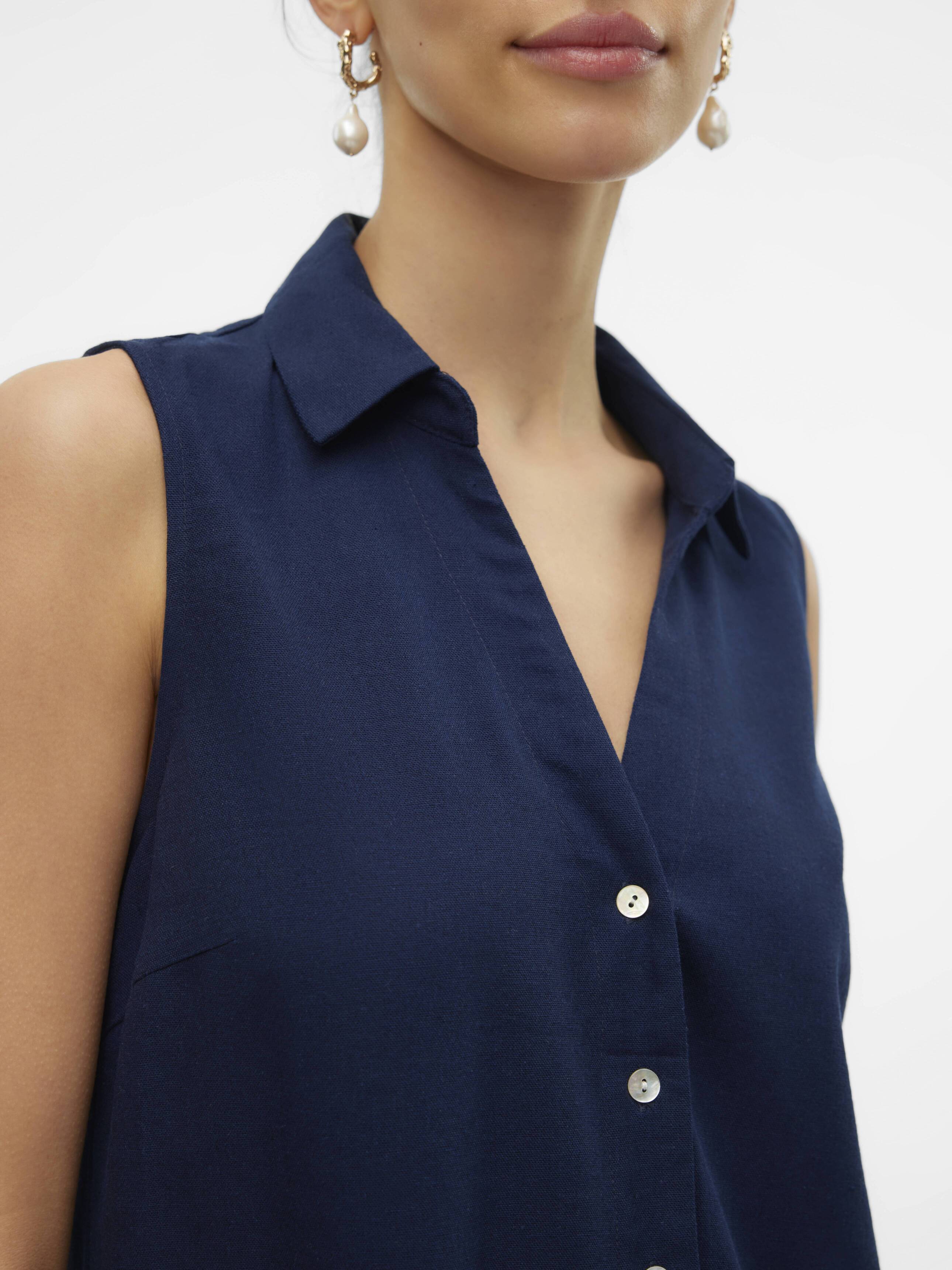 Close-up of navy Vero Moda My Nen Sleeveless V-Neck Top with button front and collar detail, paired with pearl earrings.