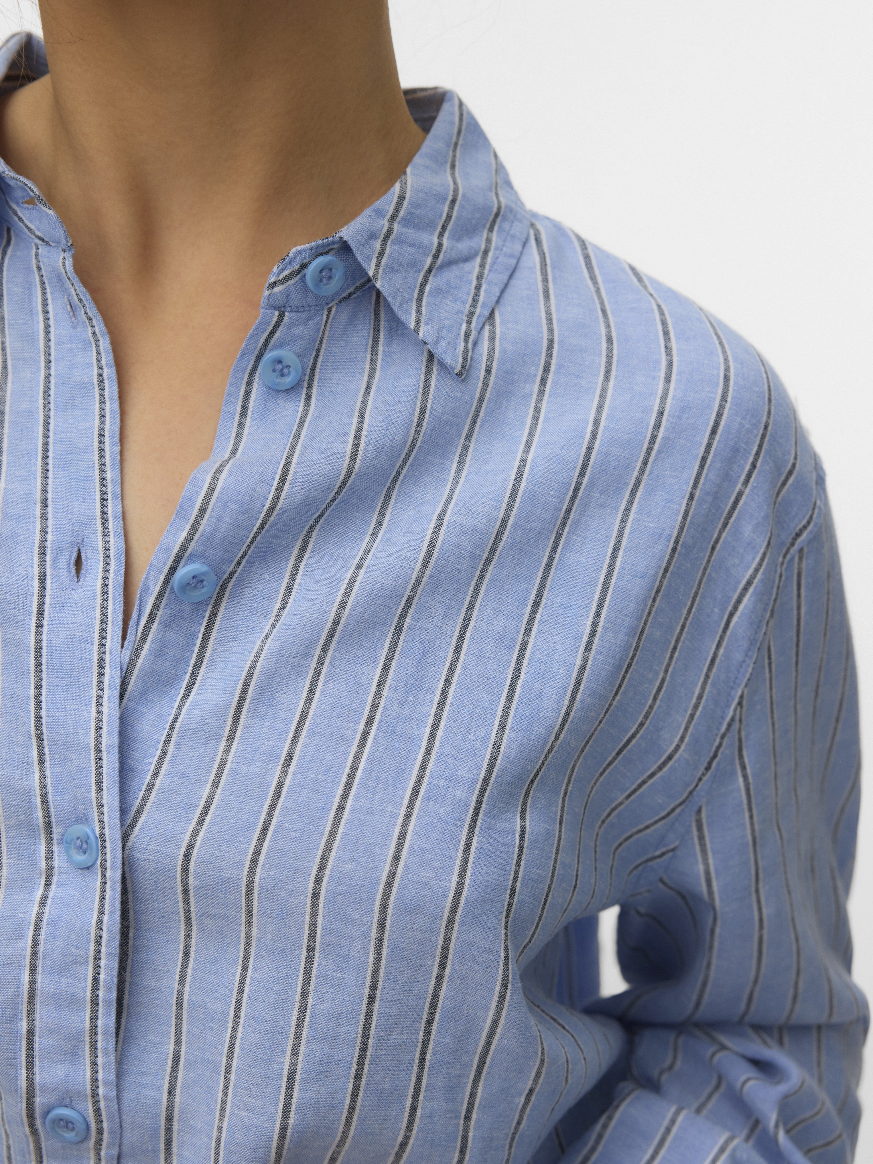 Light blue cotton shirt with thin vertical stripes and blue buttons on a simple collar design