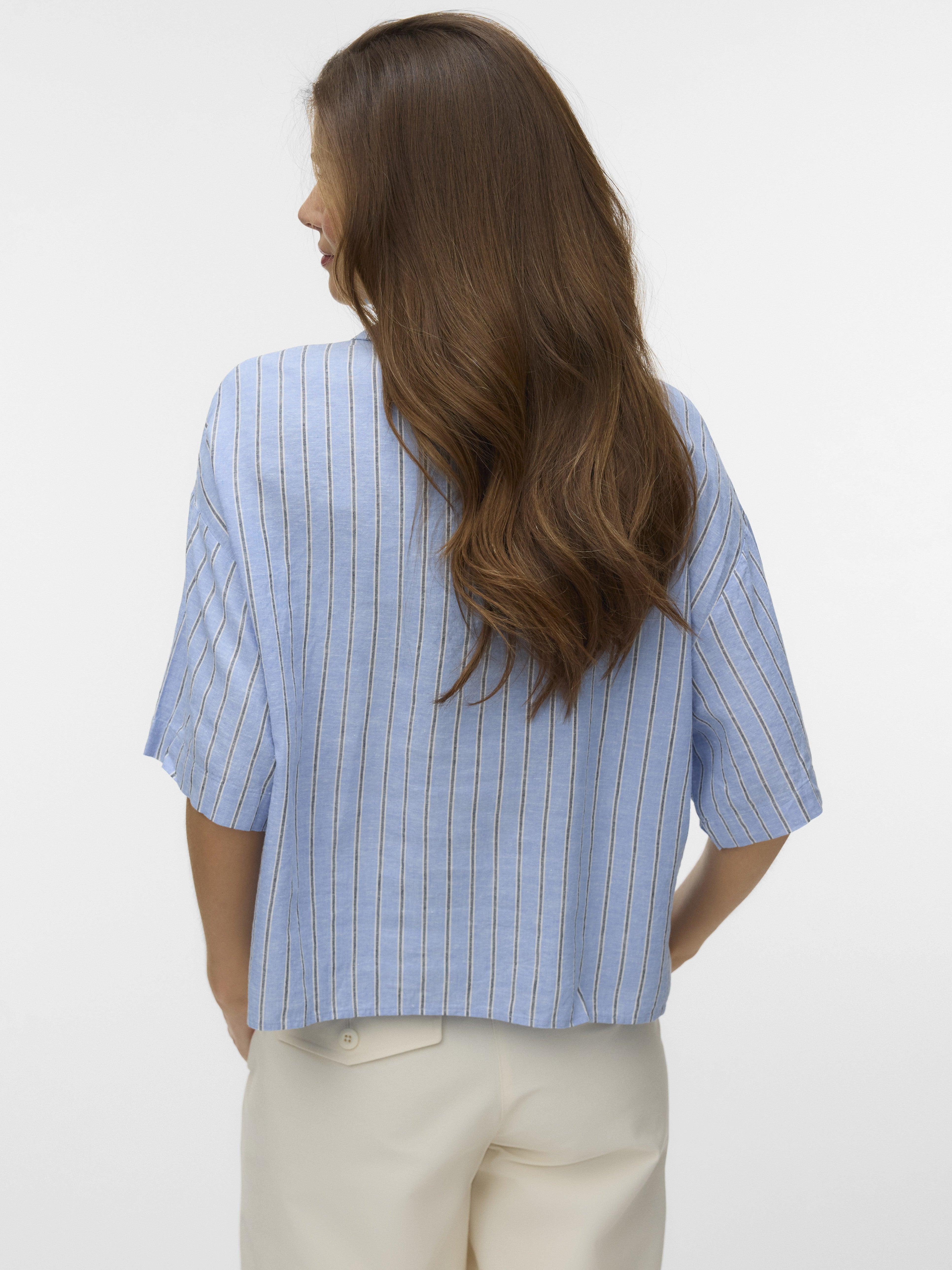 Light blue short-sleeve top with vertical stripes paired with light-colored pants, shown from the back