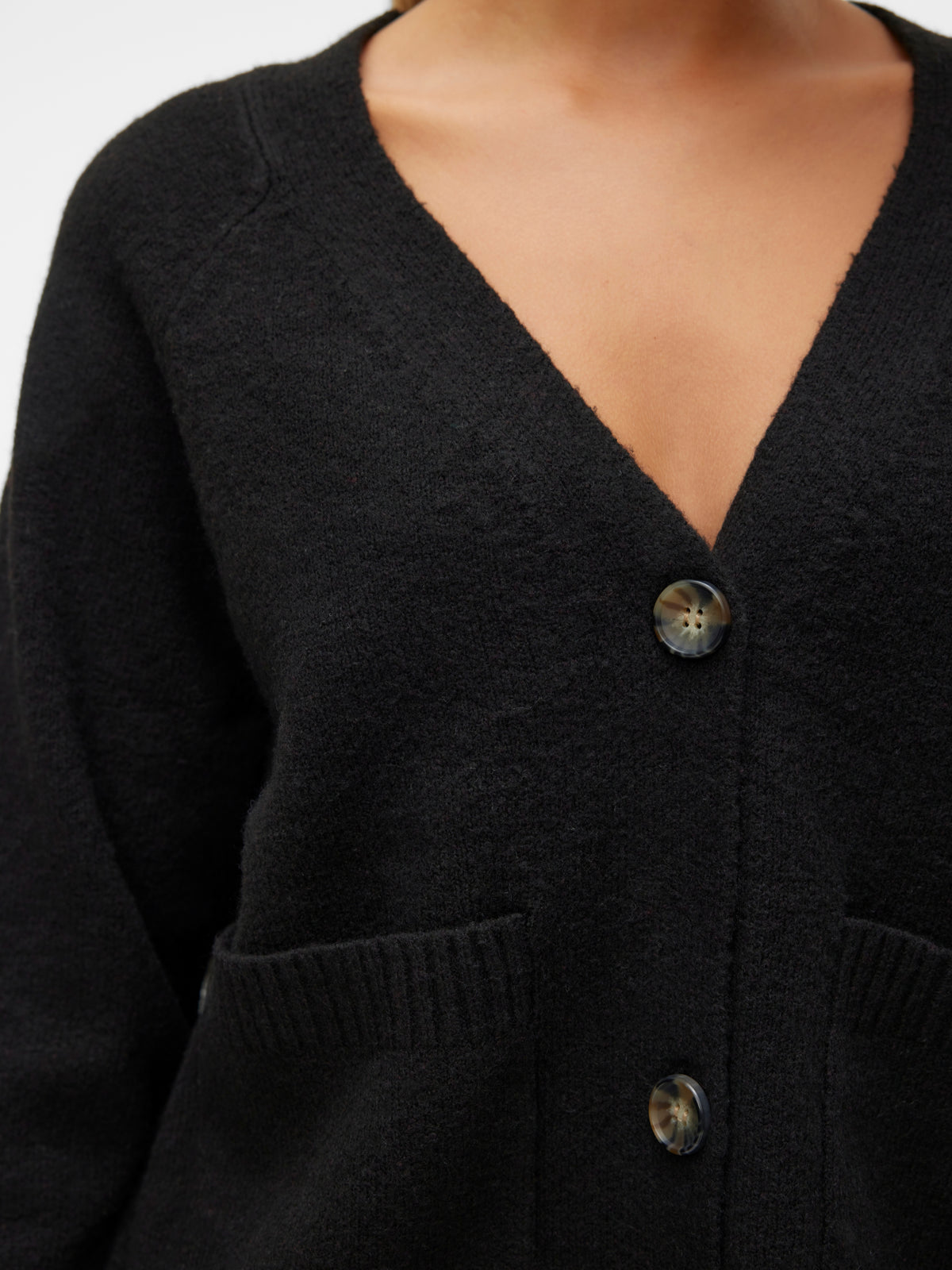 Black textured cardigan with deep V-neck, two buttons, and ribbed patch pockets on the front.
