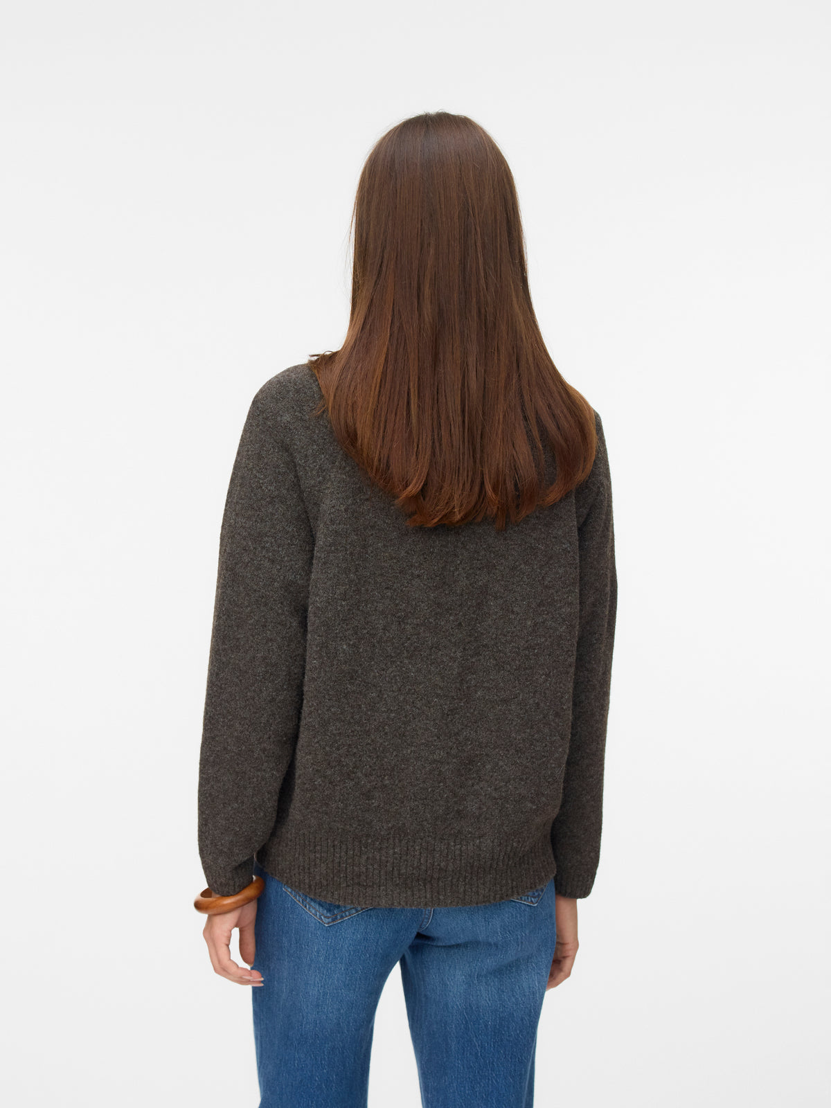 Back view of long straight brown hair over a dark gray sweater paired with blue denim jeans.