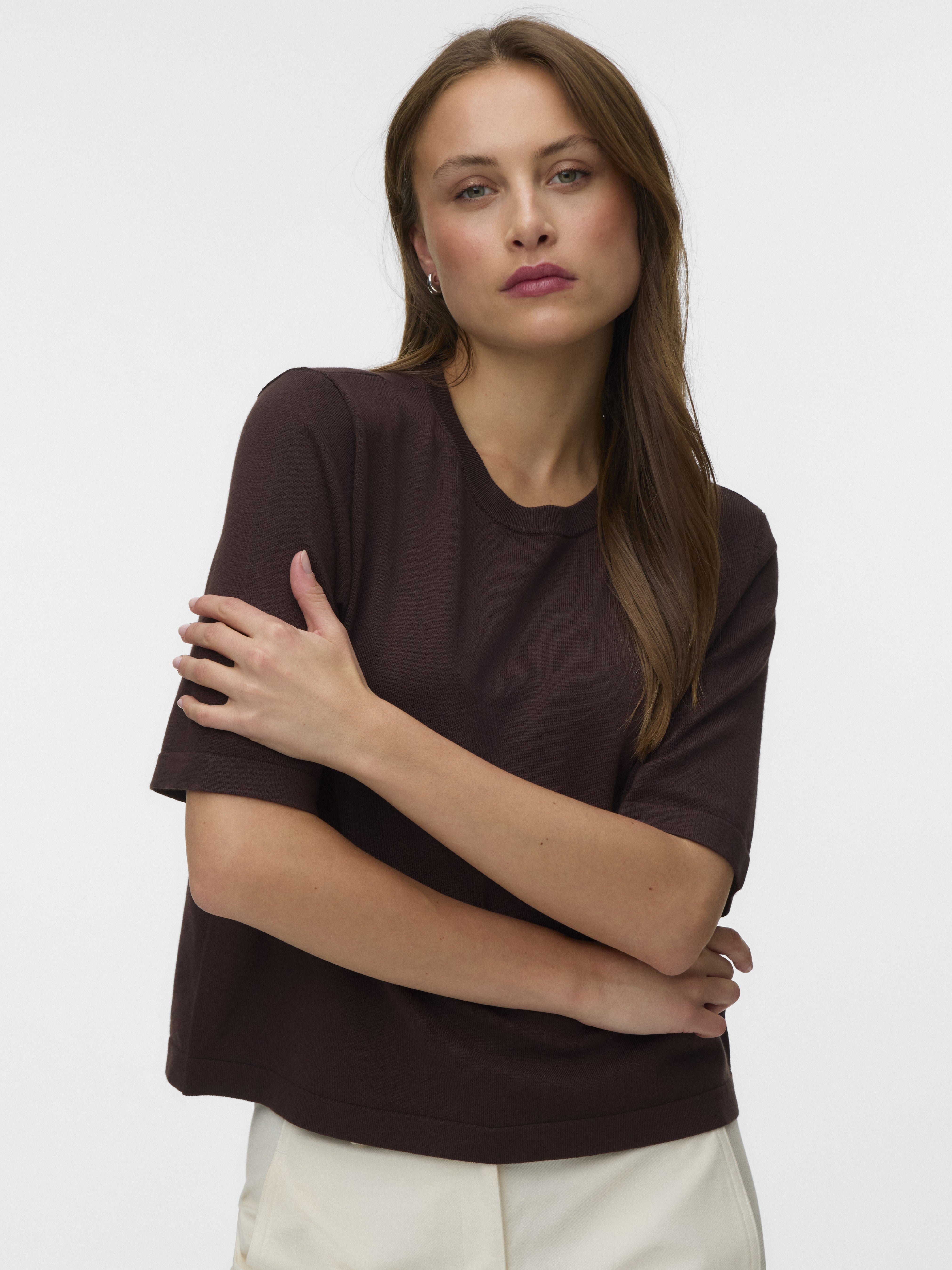 Vero Moda Silslv Crew Neck Sweater in dark chocolate color with short sleeves, styled with light trousers.