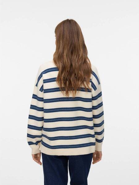 Back view of person wearing cream sweater with navy horizontal stripes and dark denim pants against white background