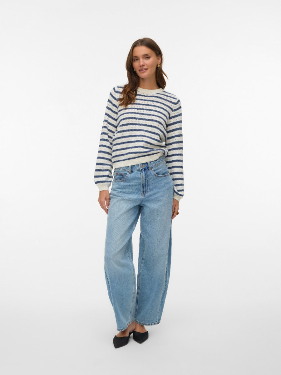 Person wearing a blue and white striped sweater paired with light blue wide-leg denim jeans and black shoes