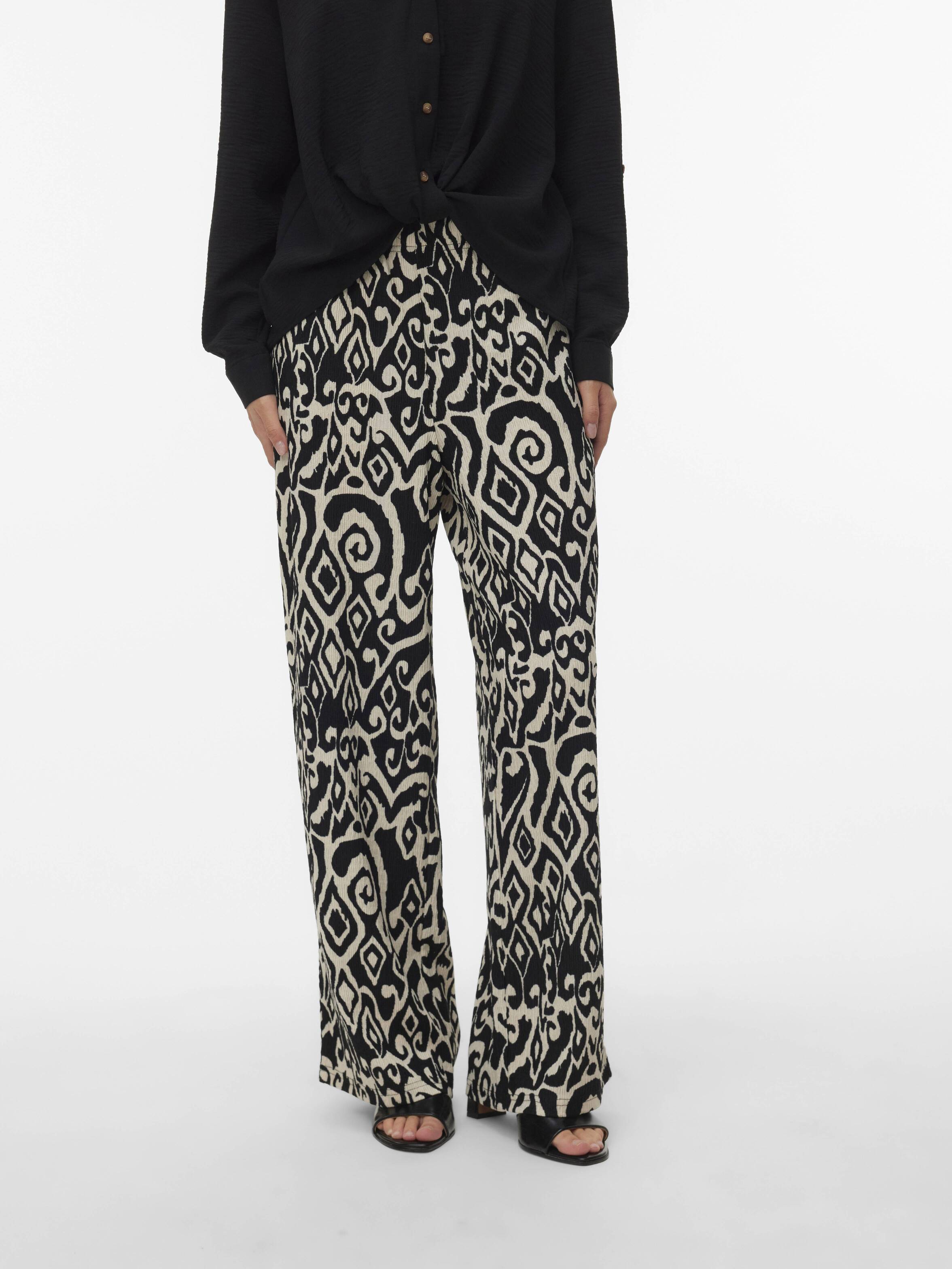 Vero Moda Friwide Wide-Leg Pants in black and beige abstract pattern paired with a black top and sandals