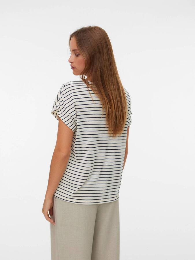 Vero Moda Holli Short Sleeve Top in beige with navy stripes modeled from the back, paired with light trousers.