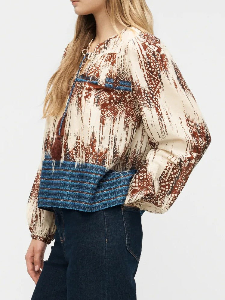 Boho-style long sleeve top with brown and cream geometric patterns and blue striped hem detail.