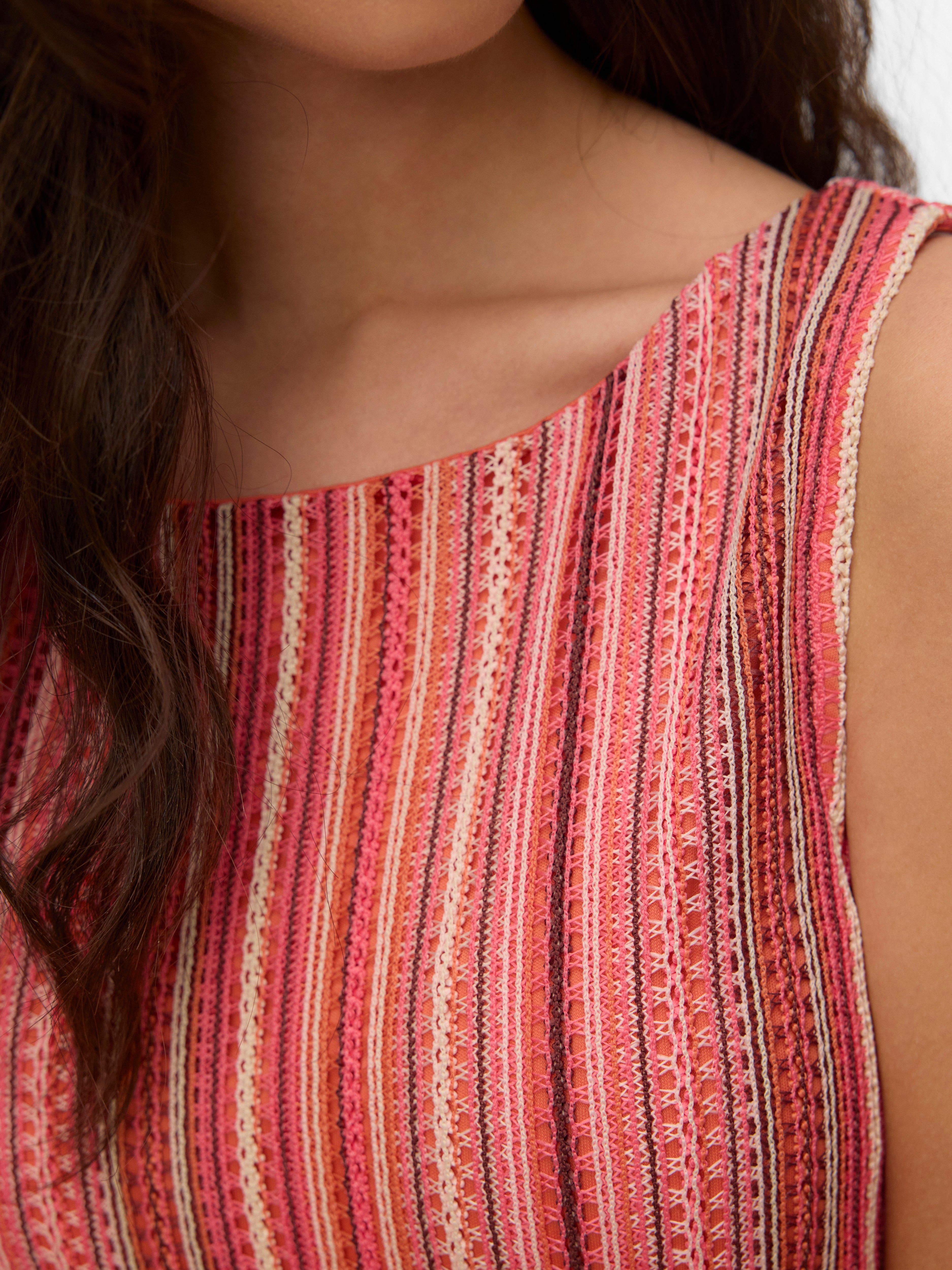 Close-up of Vero Moda Demi Crochet Sleeveless Striped Knit Top featuring coral and pink striped crochet knit fabric.