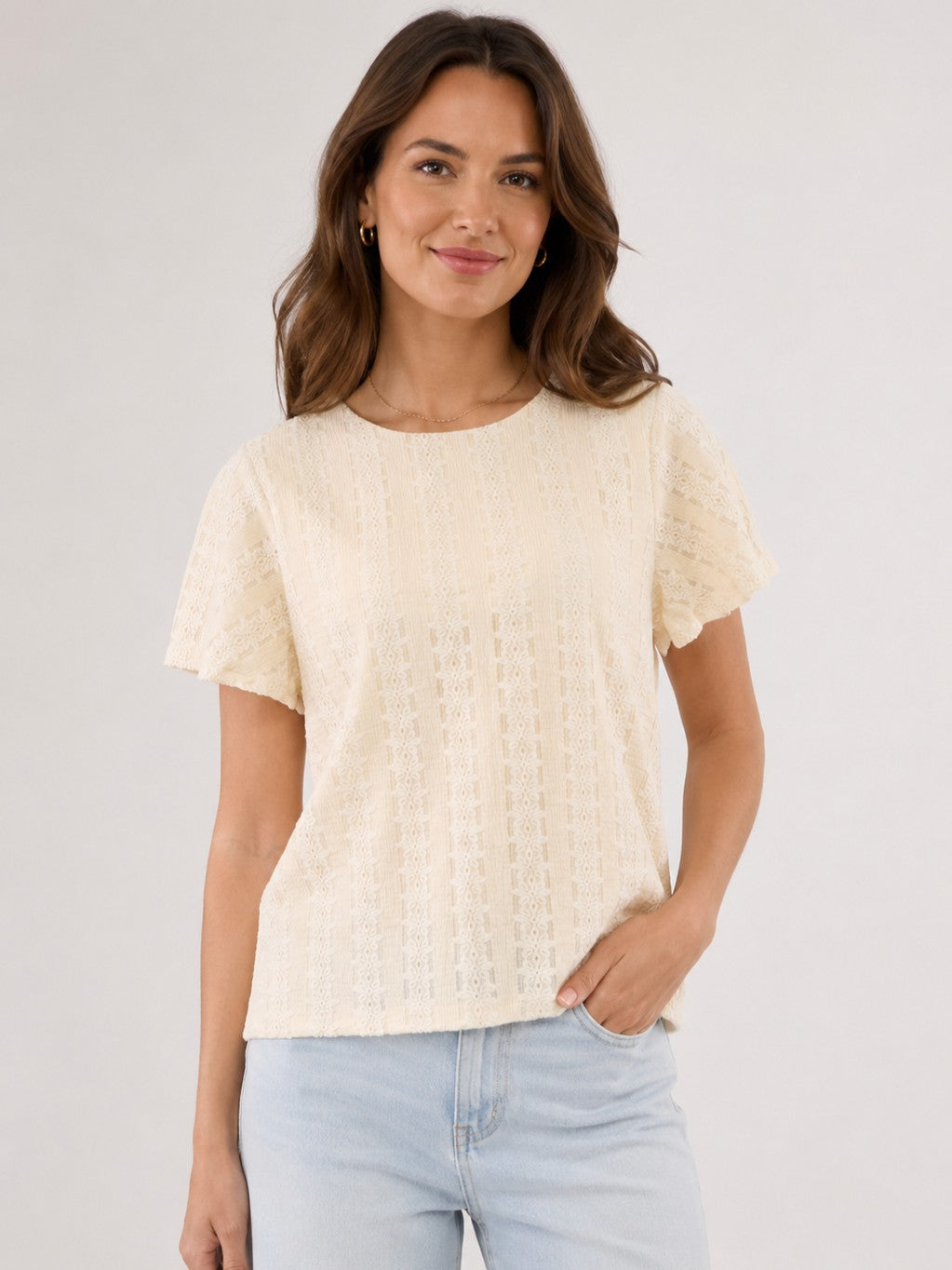 Beige Vero Moda Cassandra Eyelet Short Sleeve Top with delicate lace texture paired with light blue jeans