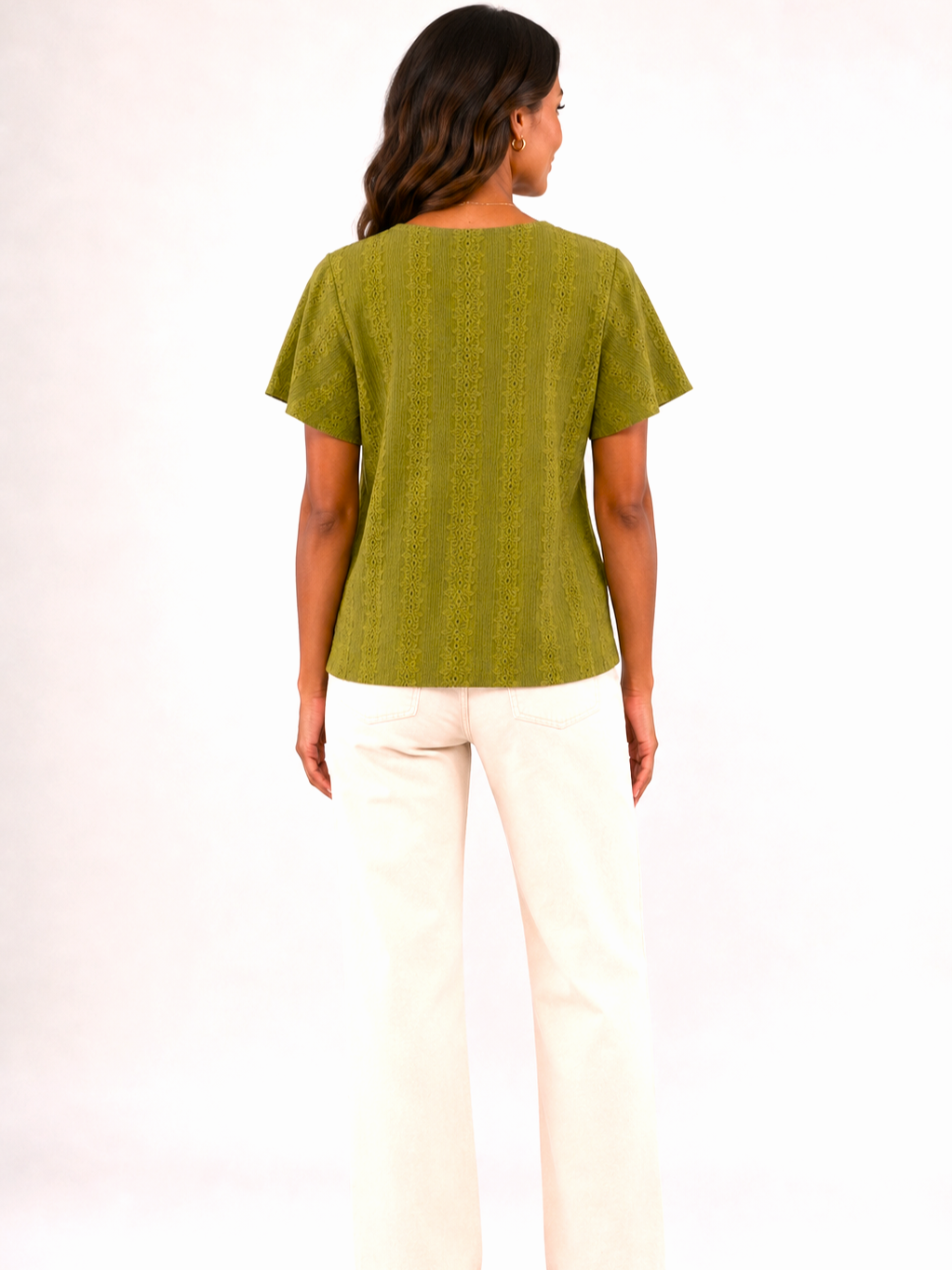 Back view of a textured lime green short-sleeve top paired with off-white straight-leg pants.