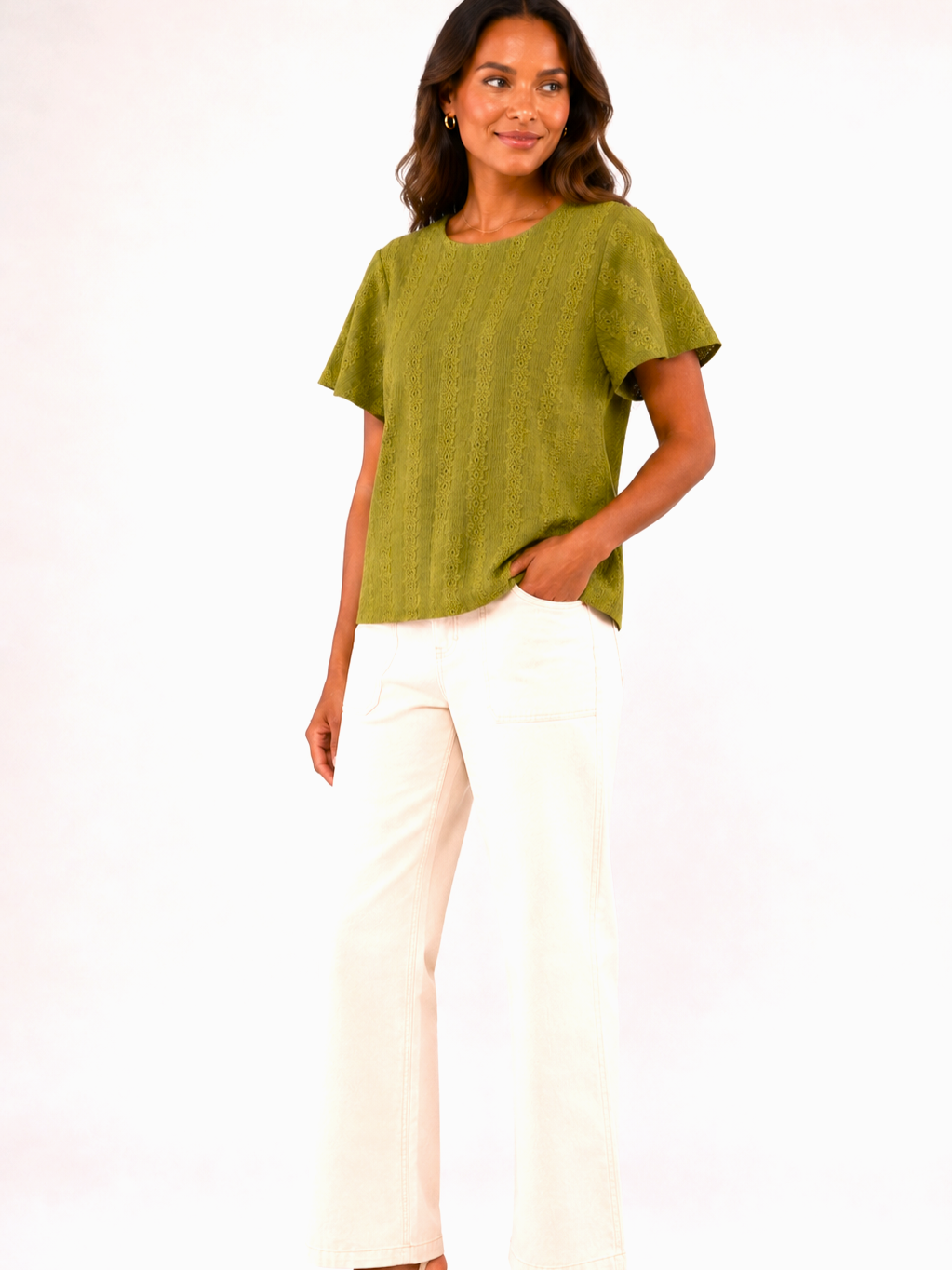 Green short-sleeve textured sweater paired with off-white wide-leg denim pants against a neutral background.