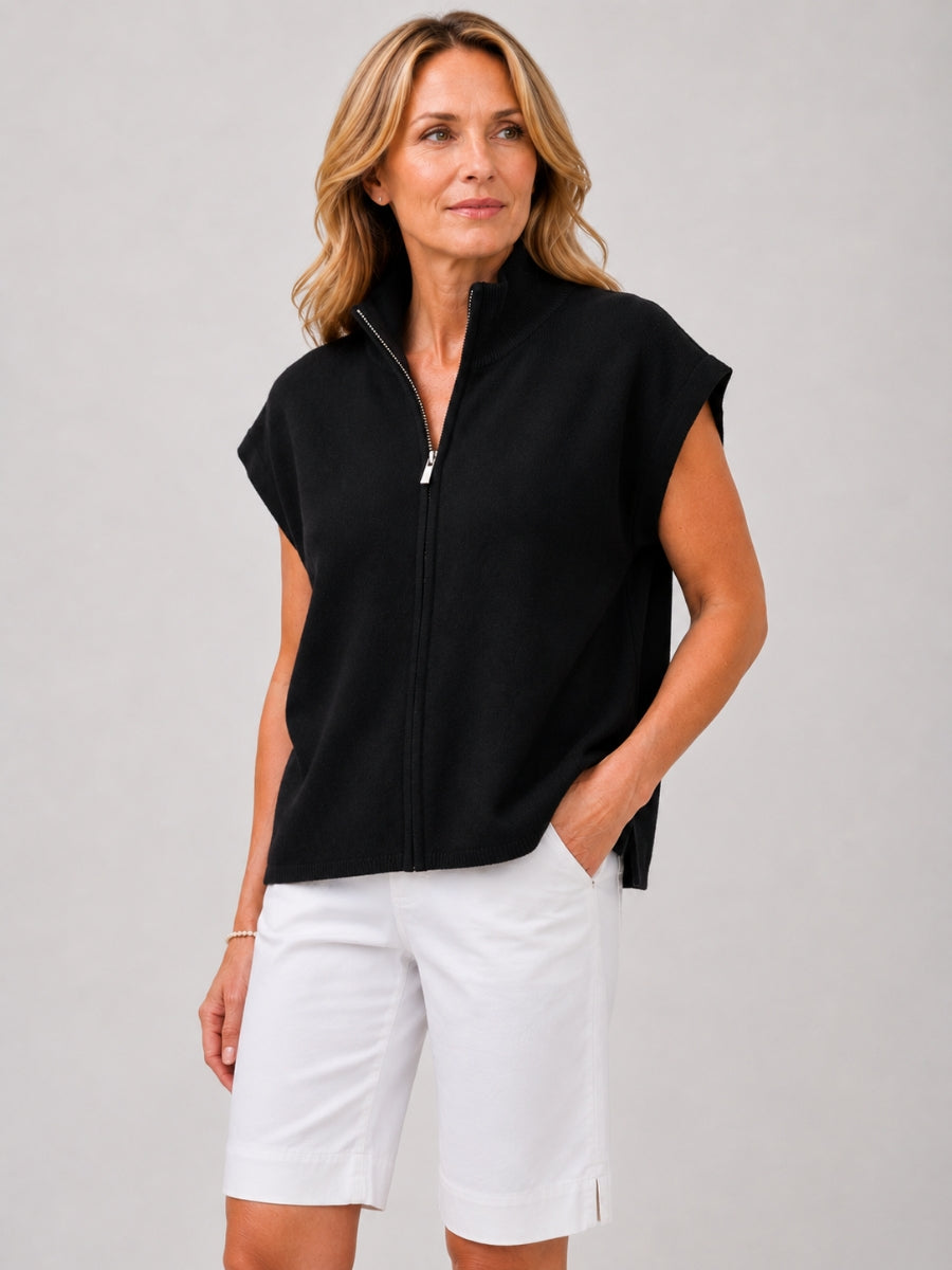 Black sleeveless zip-up top paired with white knee-length shorts on a light gray background.