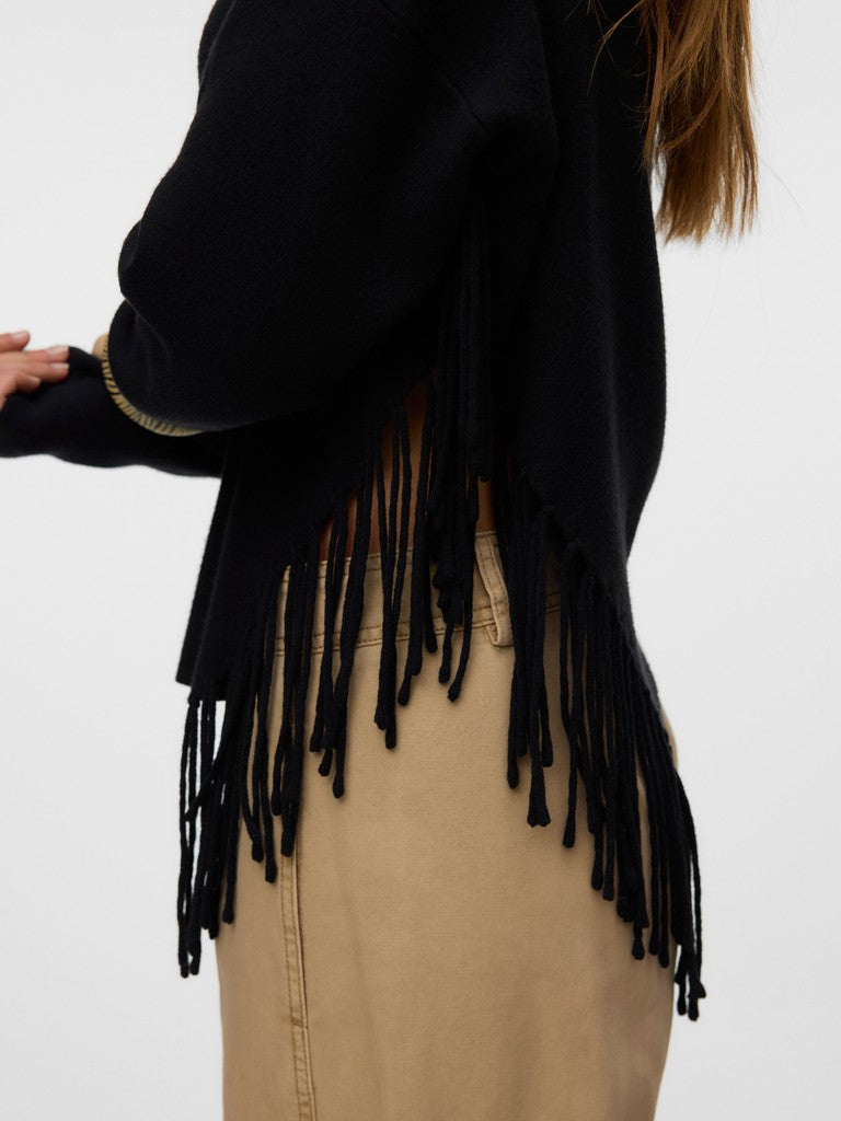 Close-up of a black fringed jacket over a tan garment