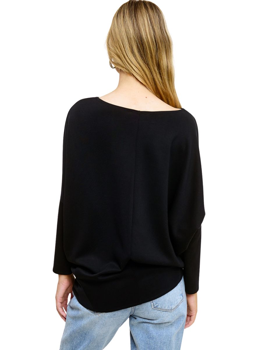 Back view of a black long-sleeve top paired with light blue denim jeans on a plain white background