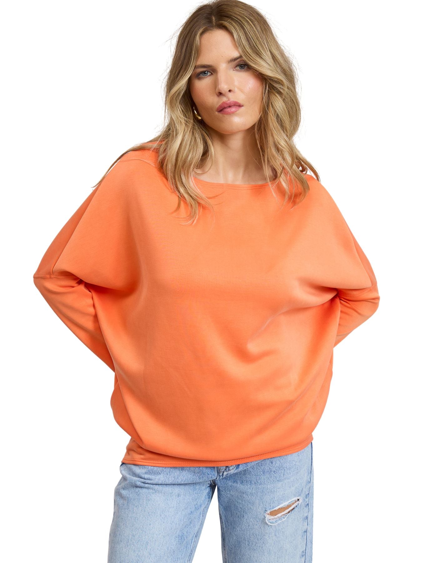 Julie Modal Dolman Top in bright orange by Jolie Inc., styled with casual light blue ripped jeans.