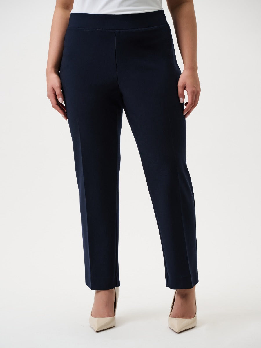 Joseph Ribkoff 29" Silky Knit Pant in navy blue by Joseph Ribkoff, styled with beige heels and a white top.