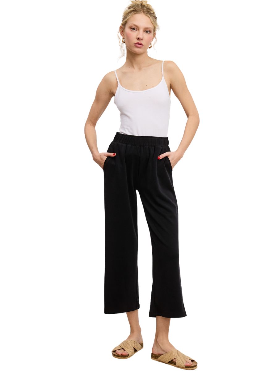 Slim fit black Charlie Modal Crop Pant by Jolie Inc. styled with a white tank top and beige slide sandals