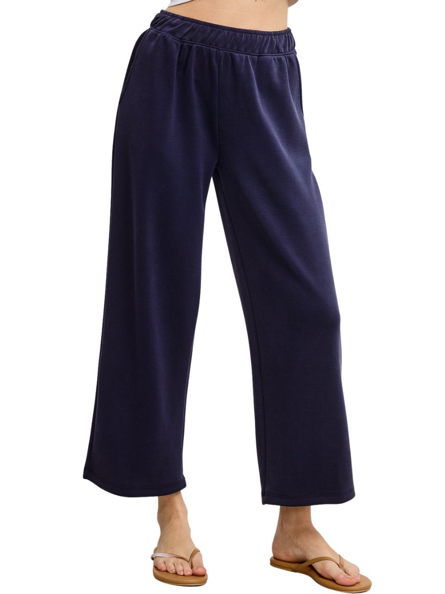 Navy blue wide-leg pants with elastic waistband paired with casual tan flip-flop sandals.
