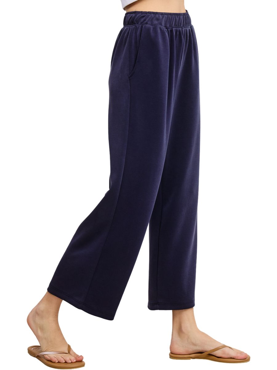 Navy blue wide-leg lounge pants with elastic waistband and side pockets paired with brown sandals.