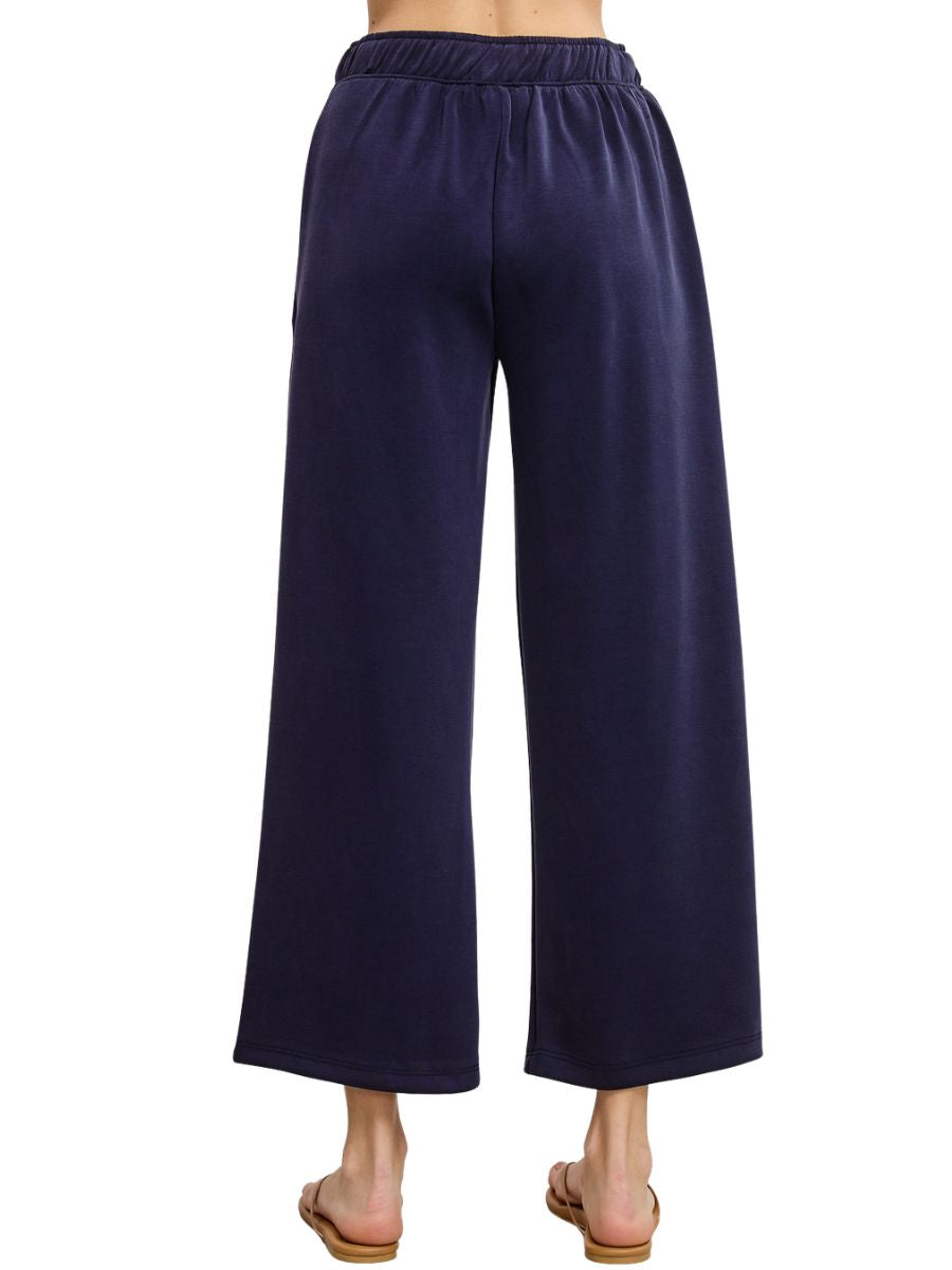 Navy blue wide-leg pants with elastic waistband and soft fabric, shown from the back with sandals.