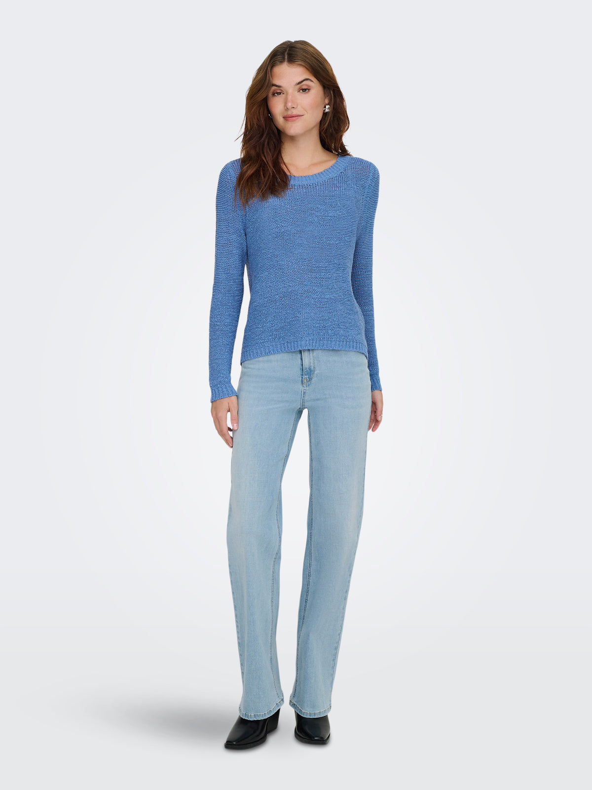 Slim-fit blue knit sweater paired with light-wash straight jeans and black ankle boots on a white background.