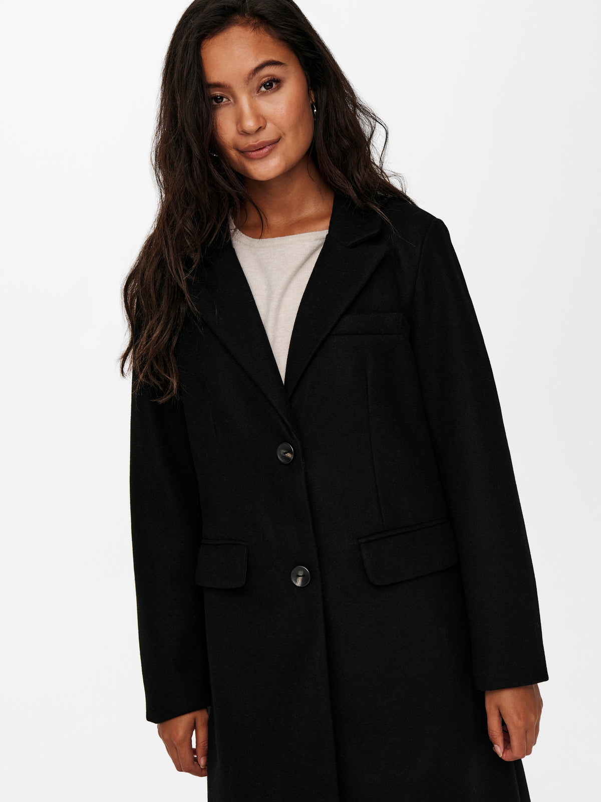Black tailored coat with notched lapels, button front, and flap pockets over a light top.