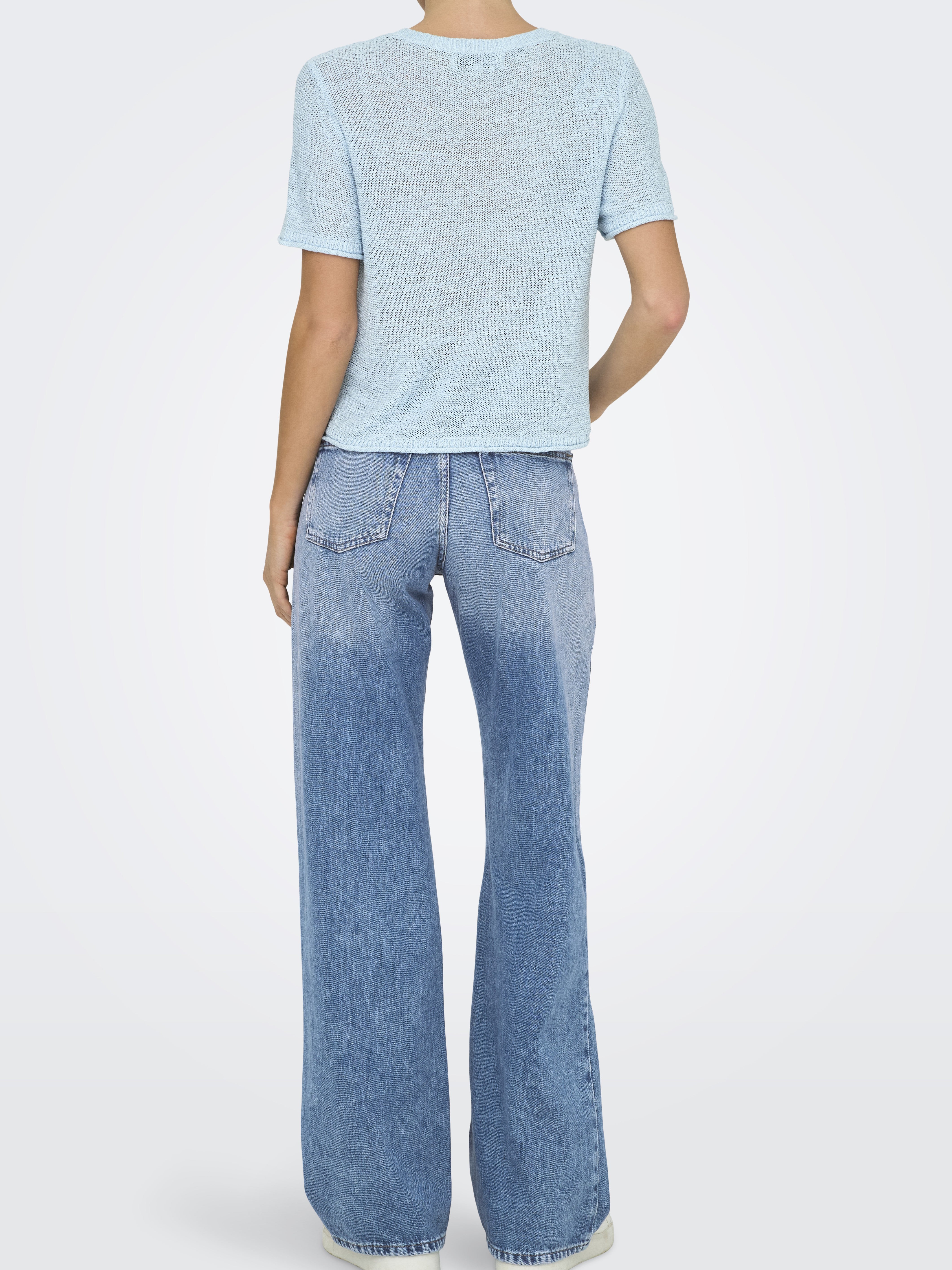 Light blue textured short-sleeve top paired with high-waisted faded blue wide-leg denim jeans viewed from the back.