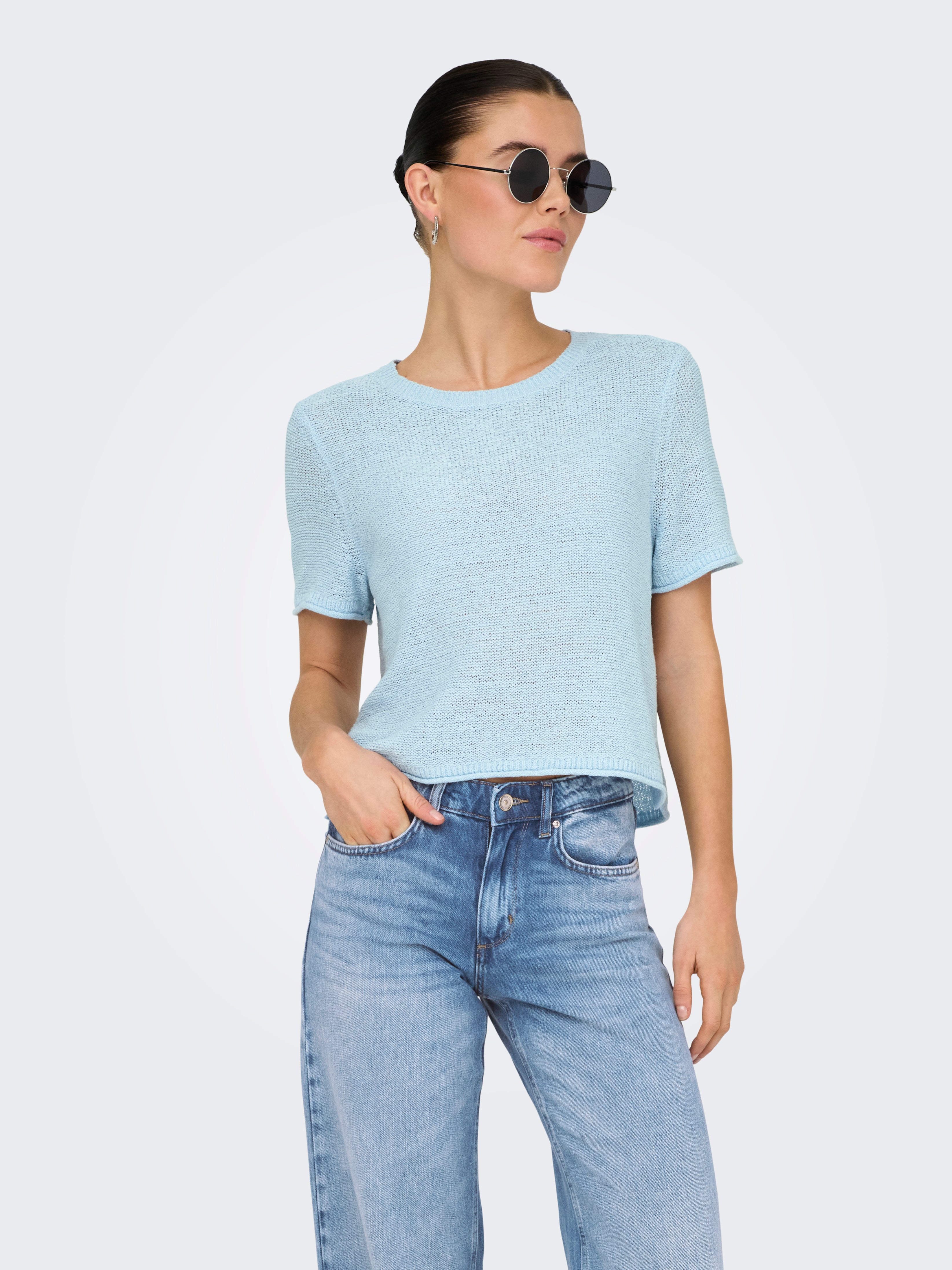 Light blue short sleeve sweater paired with denim jeans styled with round sunglasses featuring ONLY Sunny Soft Open Knit Top by Only.