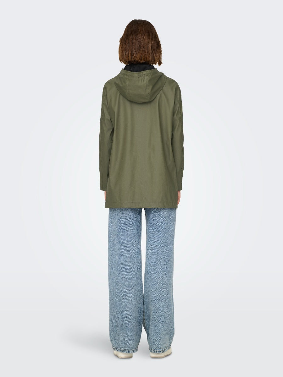 Back view of a person wearing an olive green hooded ONLY New Ellen Raincoat by Only with blue jeans and white shoes.