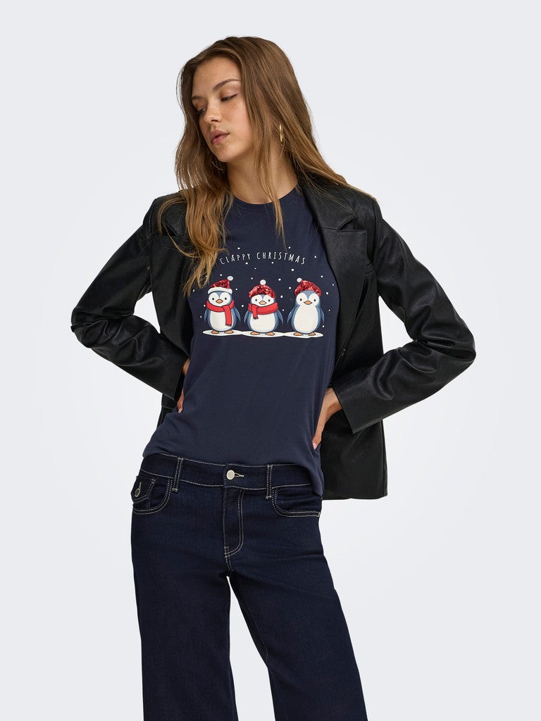 Black leather jacket over a navy Christmas graphic top with snowmen and dark denim jeans