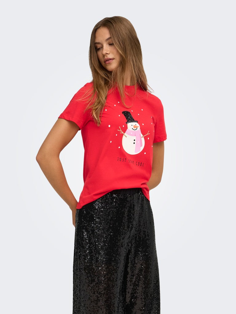 Red graphic top with a snowman print paired with a black sequined skirt against a light background