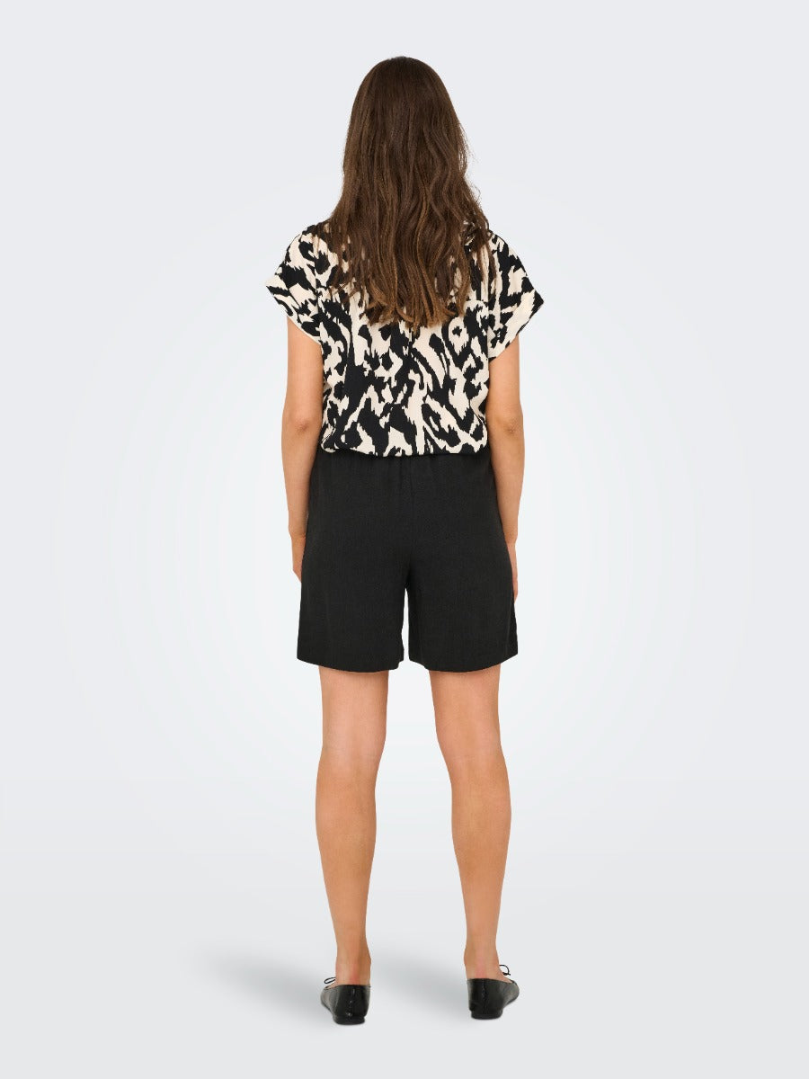 Back view of ONLY Siesta Linen Blend Short in black paired with printed short-sleeve top by Only.