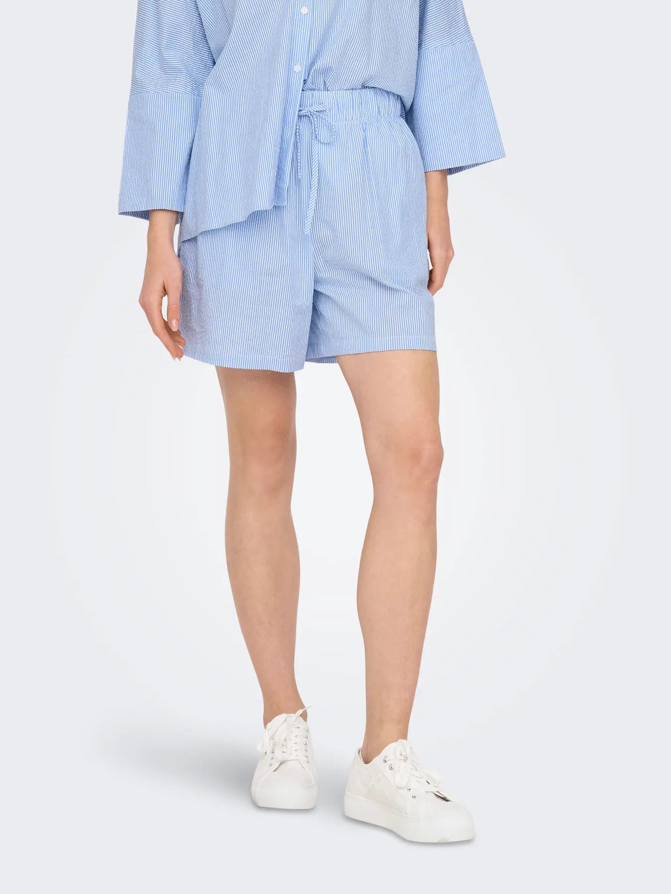 Only Augusta Stripe Cotton Shorts in light blue striped cotton, paired with white casual sneakers by Only.