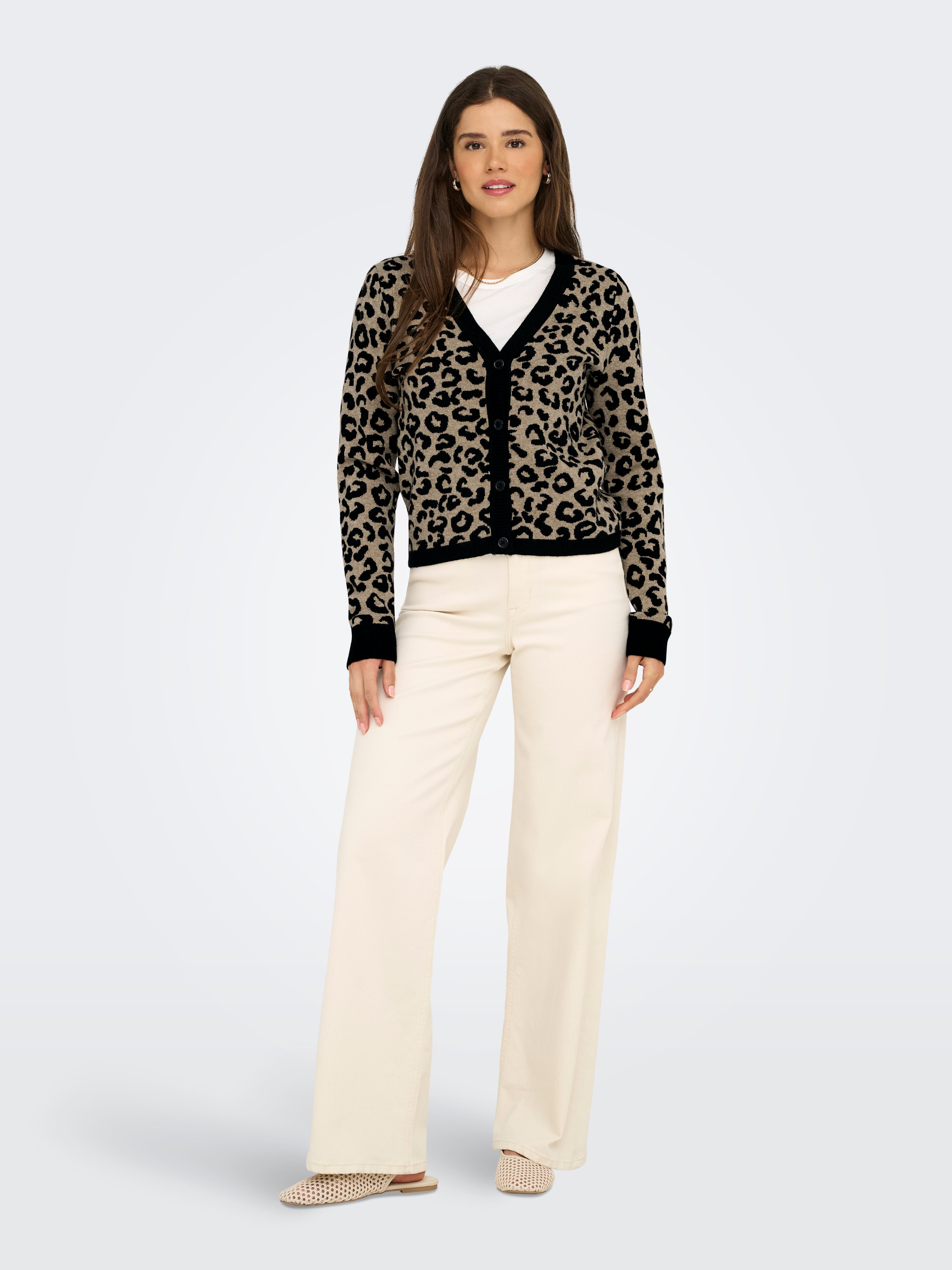 Leopard print cardigan with black trim paired with a white top and wide-leg cream-colored pants and flats.