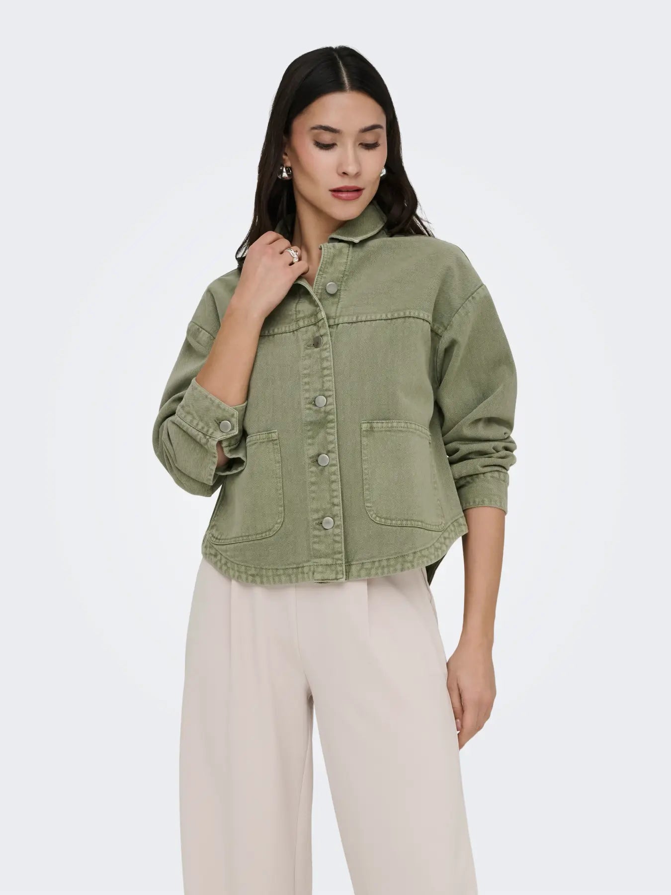 Olive green Jacqueline De Yong Noma Long Sleeve Shacket jacket with front pockets and button closure, styled with light trousers.
