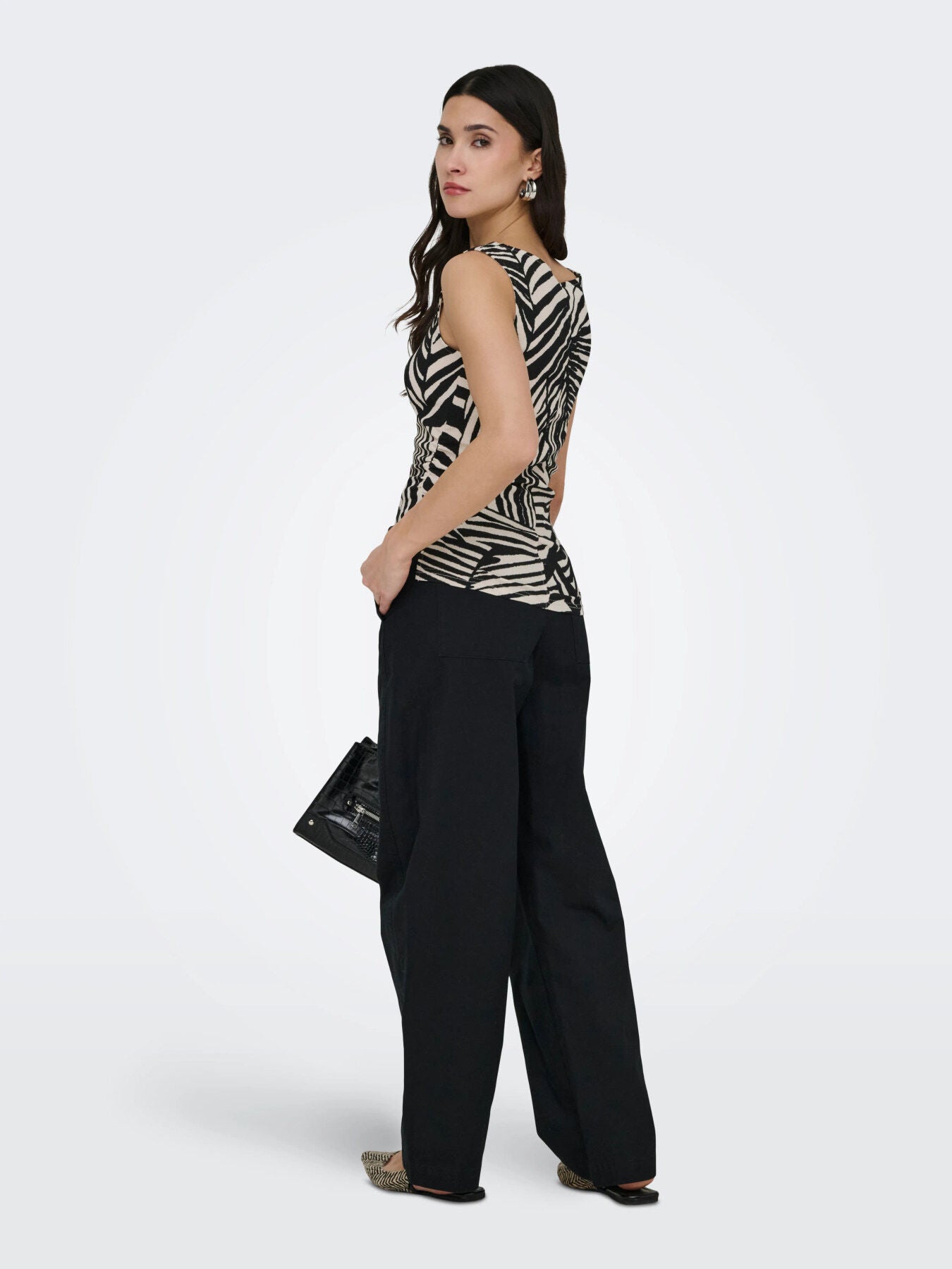 Jacqueline De Yong Debbie Sleeveless Top with black and beige leaf pattern styled with black wide-leg pants and earrings by Jacqueline De Yong