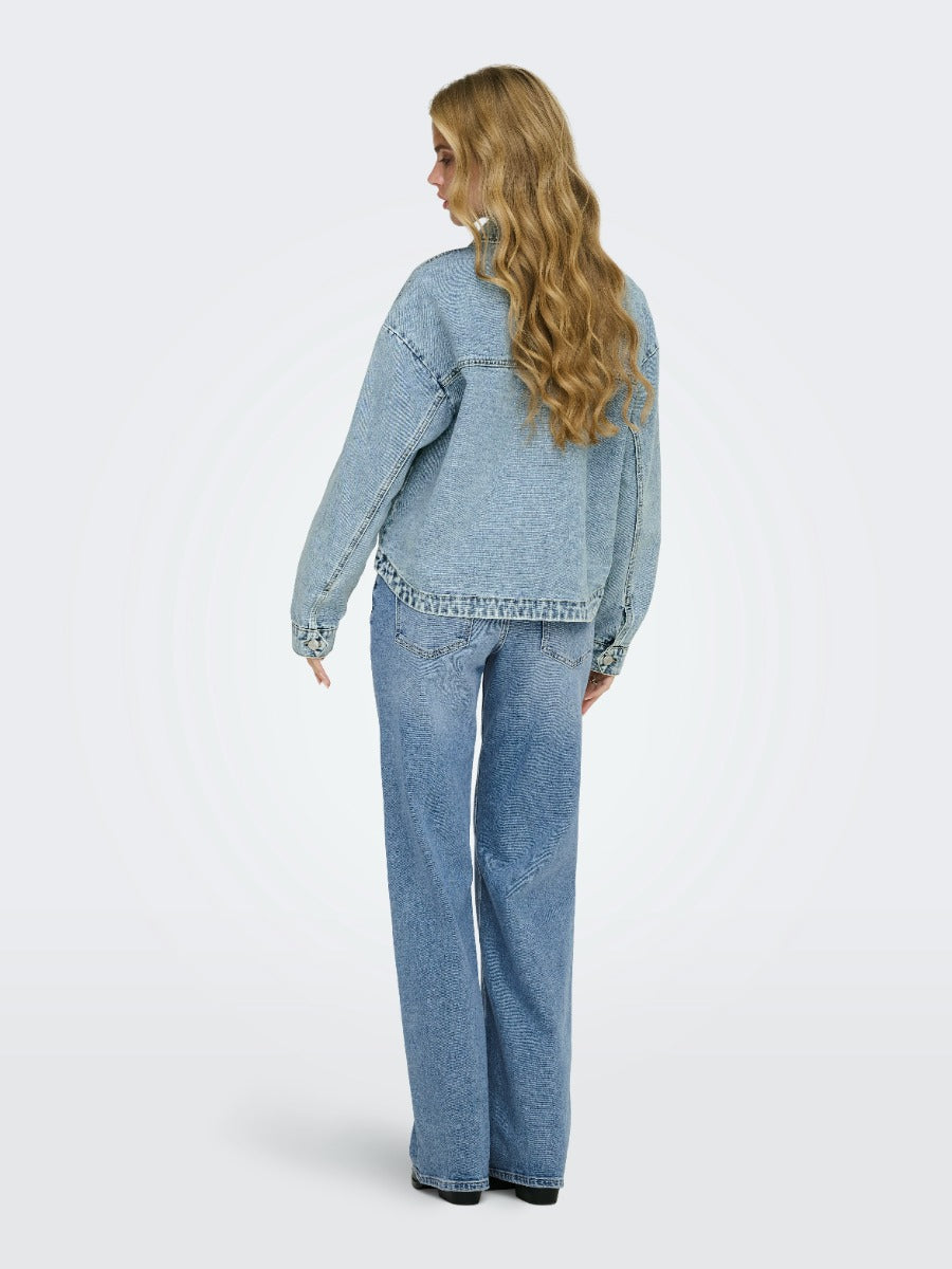 Back view of ONLY Ferbie Women’s Double Pocket Denim Jacket in light blue denim by Only, paired with blue jeans.